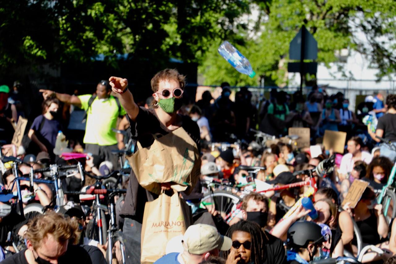 A man throws a bottle of water into the crowd during a protest on June 2, 2020. Temperatures exceeded 80 degrees as people handed out water, snacks and sunscreen to protesters. (Evan Garcia / WTTW News)