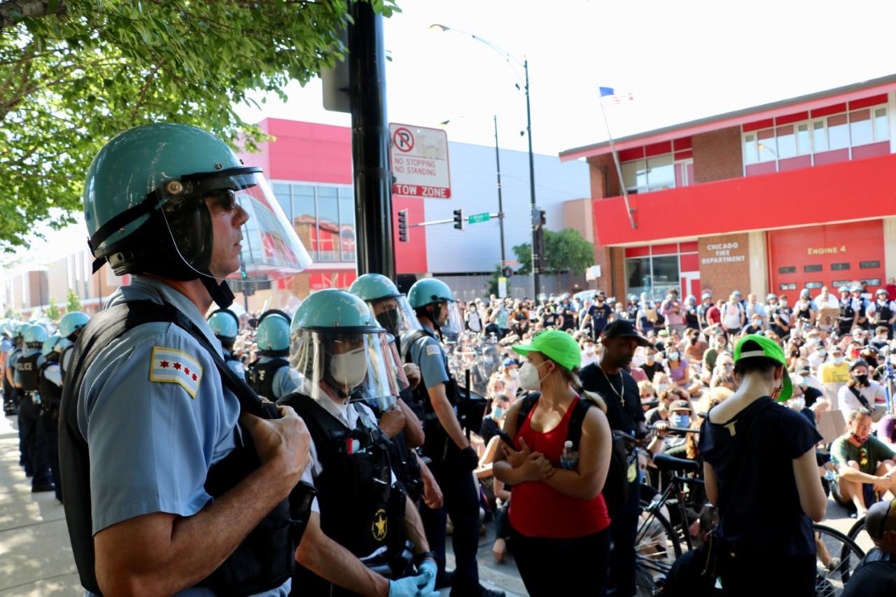 A line of Chicago police officers watch the demonstration at Division and Larrabee streets on June 2, 2020. Protesters assembled in front of a fire station and adjacent to the police department’s 18th District station. (Evan Garcia / WTTW News)
