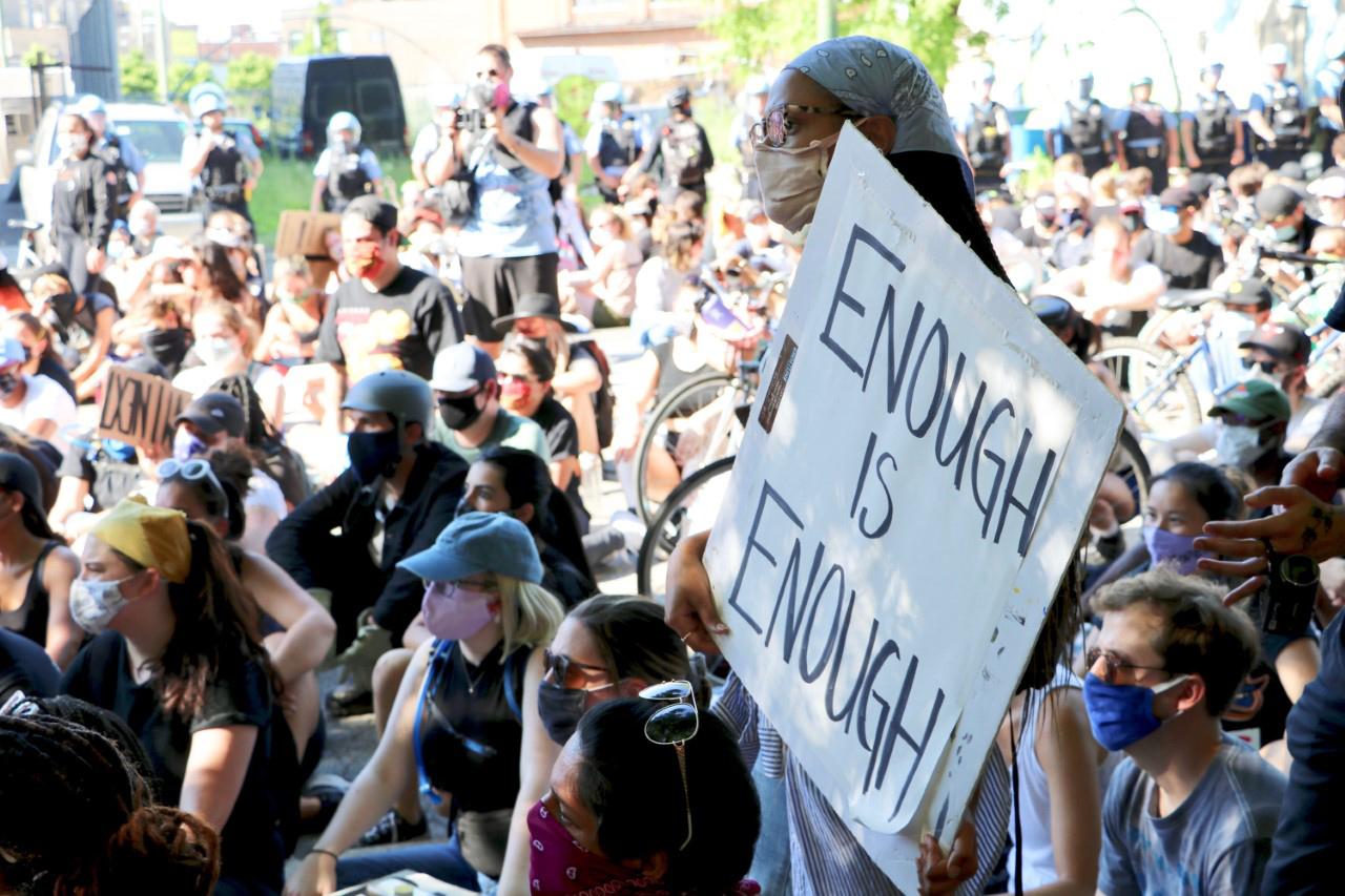 A woman holds a sign reading “Enough Is Enough” during a protest on June 2, 2020 in Old Town. (Evan Garcia / WTTW News)