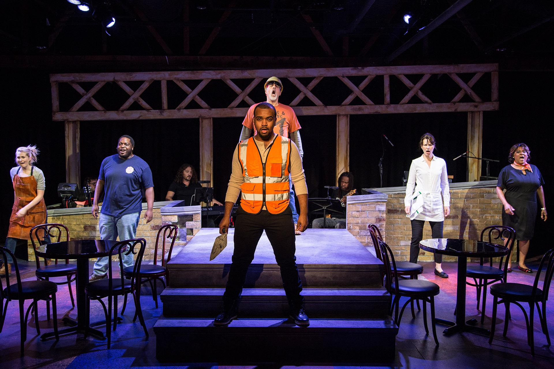 Kiersten Frumkin (left to right), Jared David Michael Grant, Stephen Blu Allen, Michael Kingston, Loretta Rezos and Cynthia F. Carter in “Working.” Background, in band are Perry Cowdery (left to right), Jeremy Ramey and Rafe Bradford. (Photo by Austin Oie Photography) 