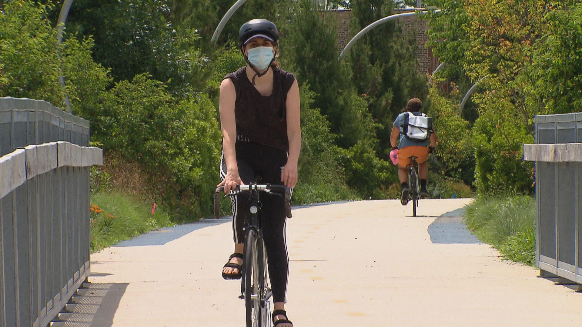A cyclist wearing a mask rides along the 606 trail in Chicago. (WTTW News)