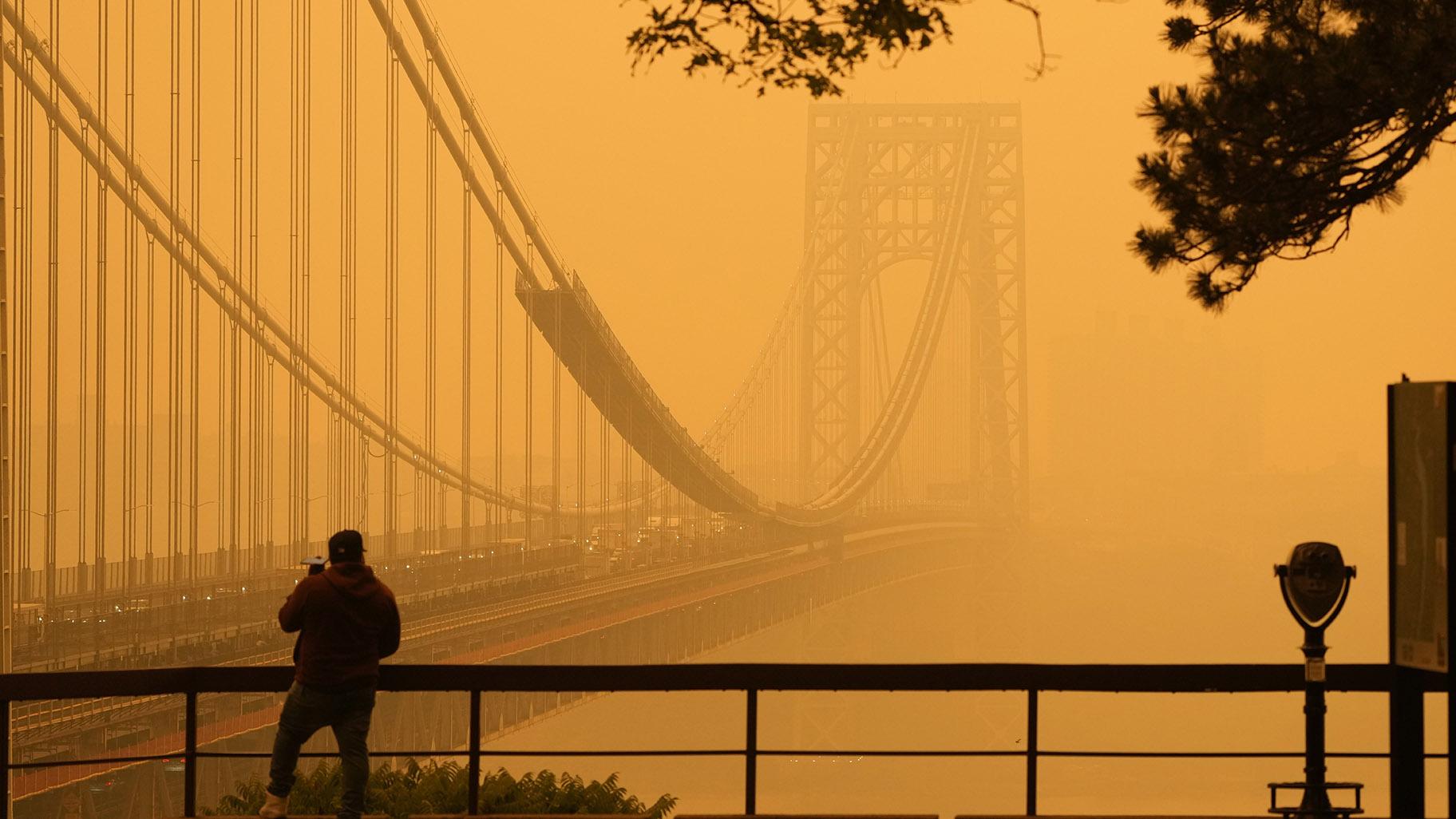 A Man talks on his phone as he looks through the haze at the George Washington Bridge from Englewood Cliffs, N.J., Wednesday, June 7, 2023. (AP Photo / Seth Wenig)