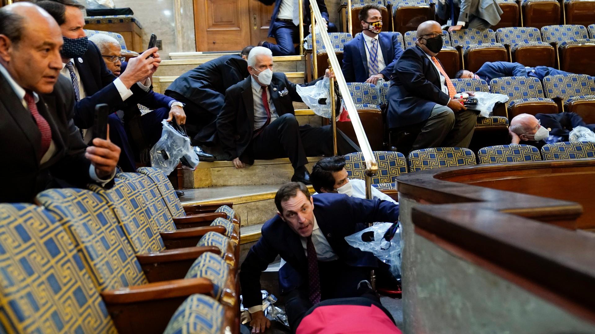 People shelter in the House gallery as protesters try to break into the House Chamber at the U.S. Capitol on Wednesday, Jan. 6, 2021, in Washington. (AP Photo / Andrew Harnik)