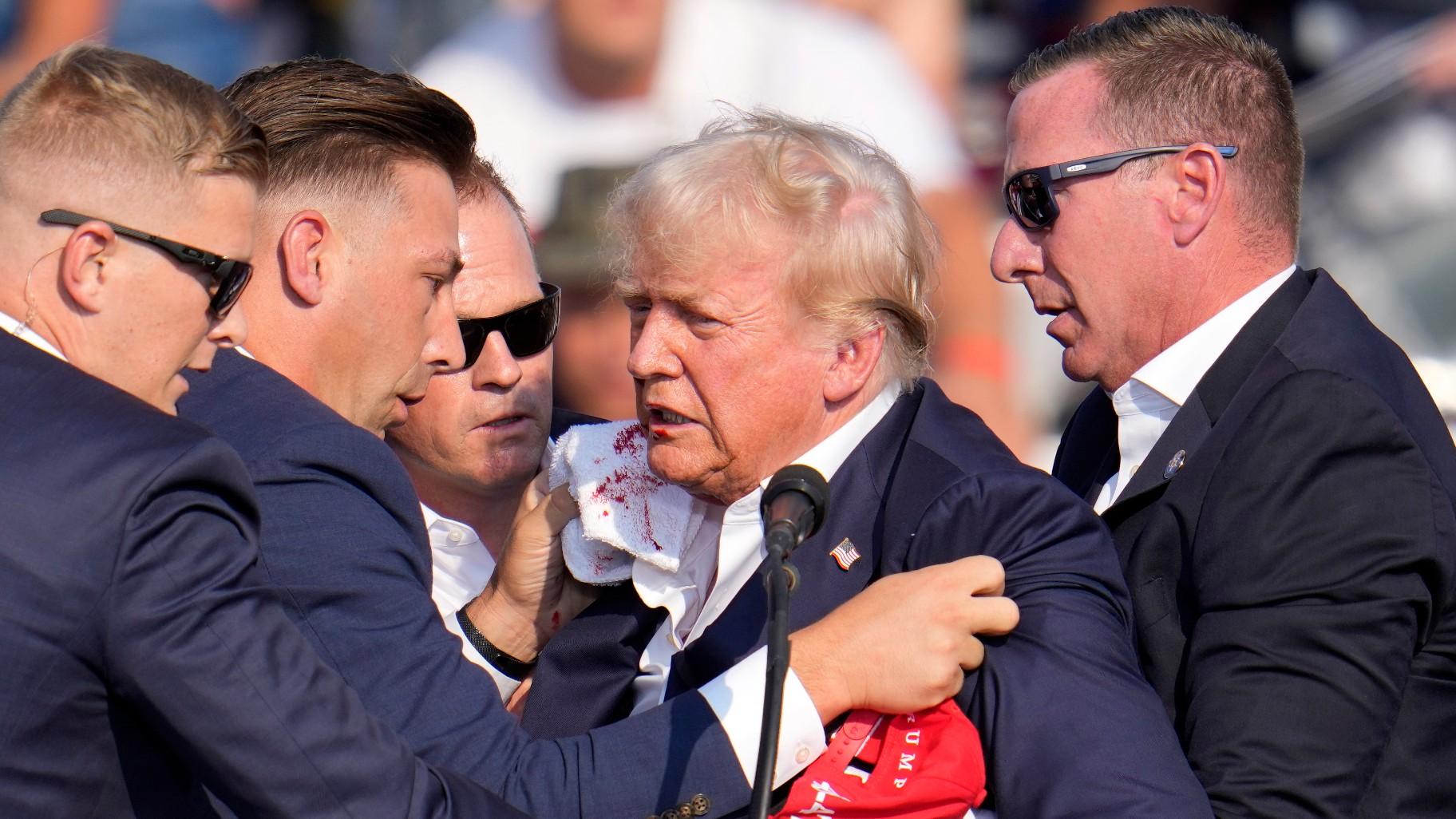 Republican presidential candidate former President Donald Trump is helped off the stage at a campaign event in Butler, Pa., on Saturday, July 13, 2024. (AP Photo / Gene J. Puskar)
