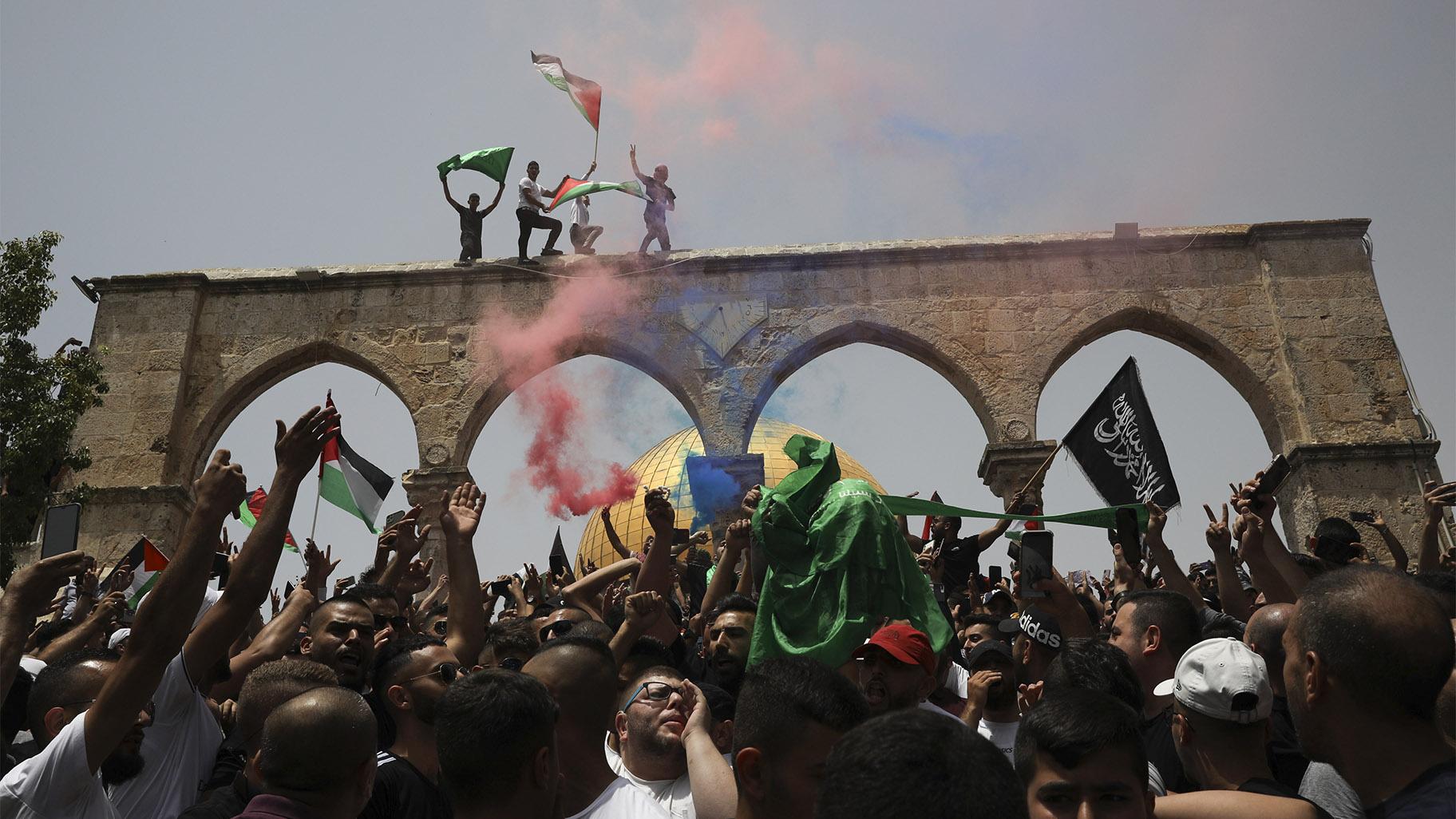 Palestinians wave national flags in front of the Dome of the Rock in the al-Aqsa mosque complex in Jerusalem, Friday, May 21, 202, as a cease-fire took effect between Hamas and Israel after an 11-day war. (AP Photo / Mahmoud Illean)