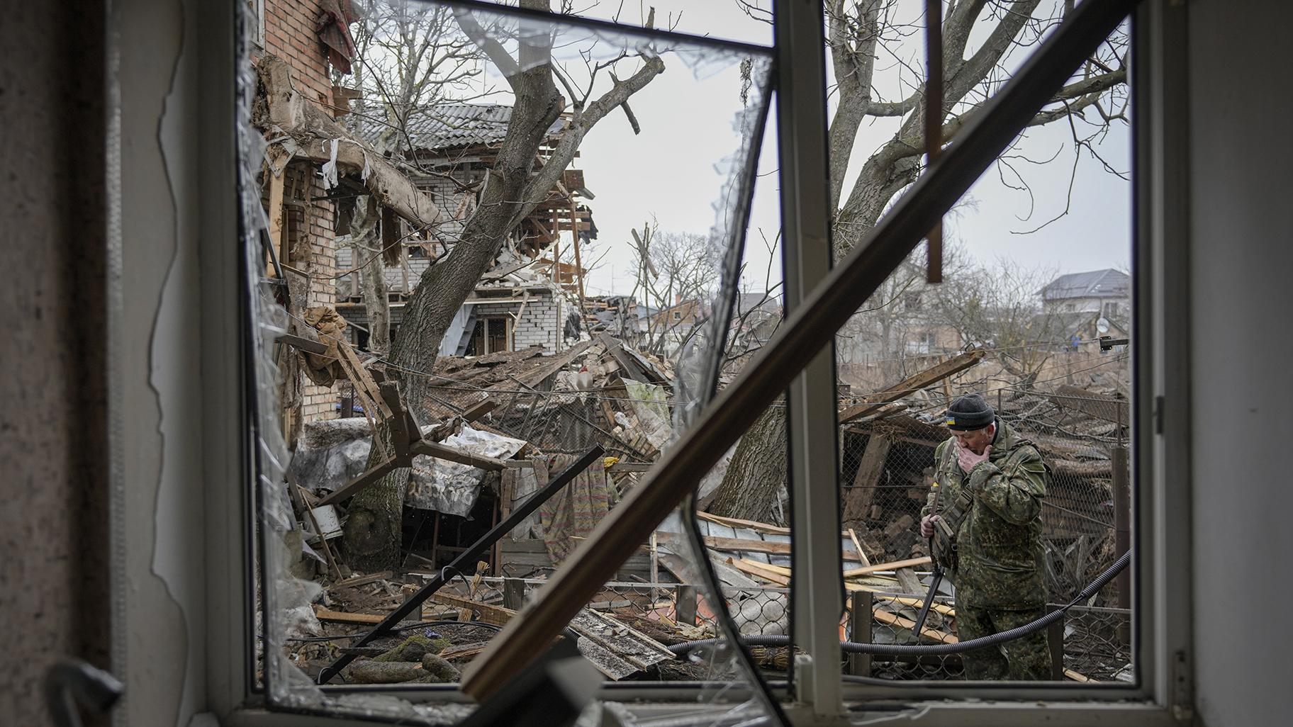 Andrey Goncharuk, 68, a member of territorial defense wipes his face in the backyard of a house that was damaged by a Russian airstrike, according to locals, in Gorenka, outside the capital Kyiv, Ukraine, Wednesday, March 2, 2022. (AP Photo / Vadim Ghirda)