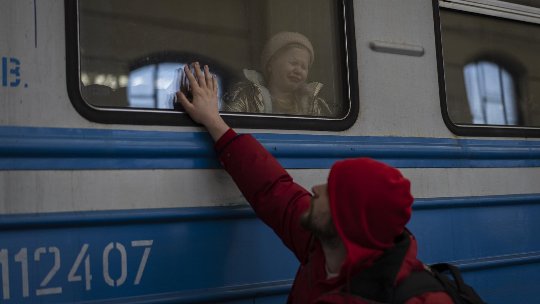 Displaced Ukrainians on a Poland-bound train bid farewell in Lviv, western Ukraine, Tuesday, March 22, 2022. (AP Photo / Bernat Armangue)
