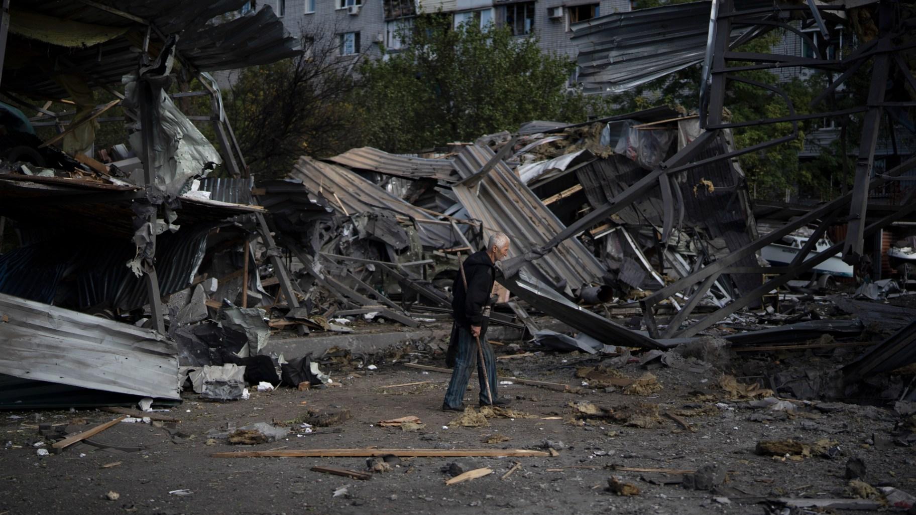 An elderly man walks past a car shop that was destroyed after a Russian attack in Zaporizhzhia, Ukraine, Tuesday, Oct. 11, 2022. (AP Photo / Leo Correa)
