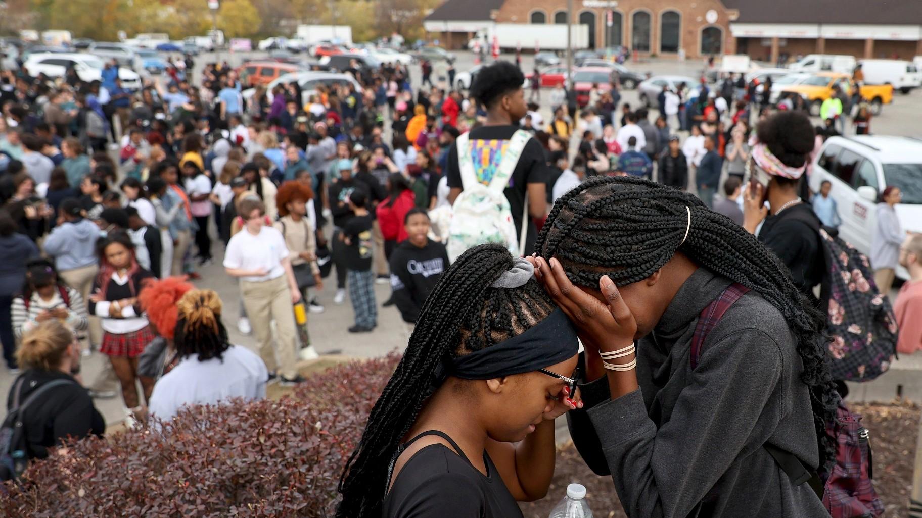Students stand in a parking lot near the Central Visual & Performing Arts High School after a reported shooting at the school in St. Louis on Monday, Oct. 24, 2022. (David Carson / St. Louis Post-Dispatch via AP)