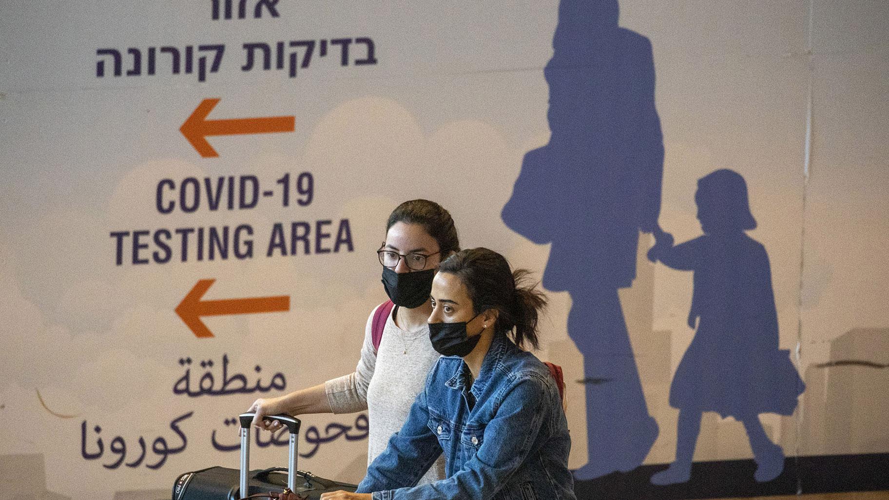 Travelers wearing protective face masks arrive at Ben Gurion Airport near Tel Aviv, Israel, Sunday, Nov. 28, 2021. Israel on Sunday approved barring entry to foreign nationals and the use of controversial technology for contact tracing as part of its efforts to clamp down on a new coronavirus variant. (AP Photo / Ariel Schalit)