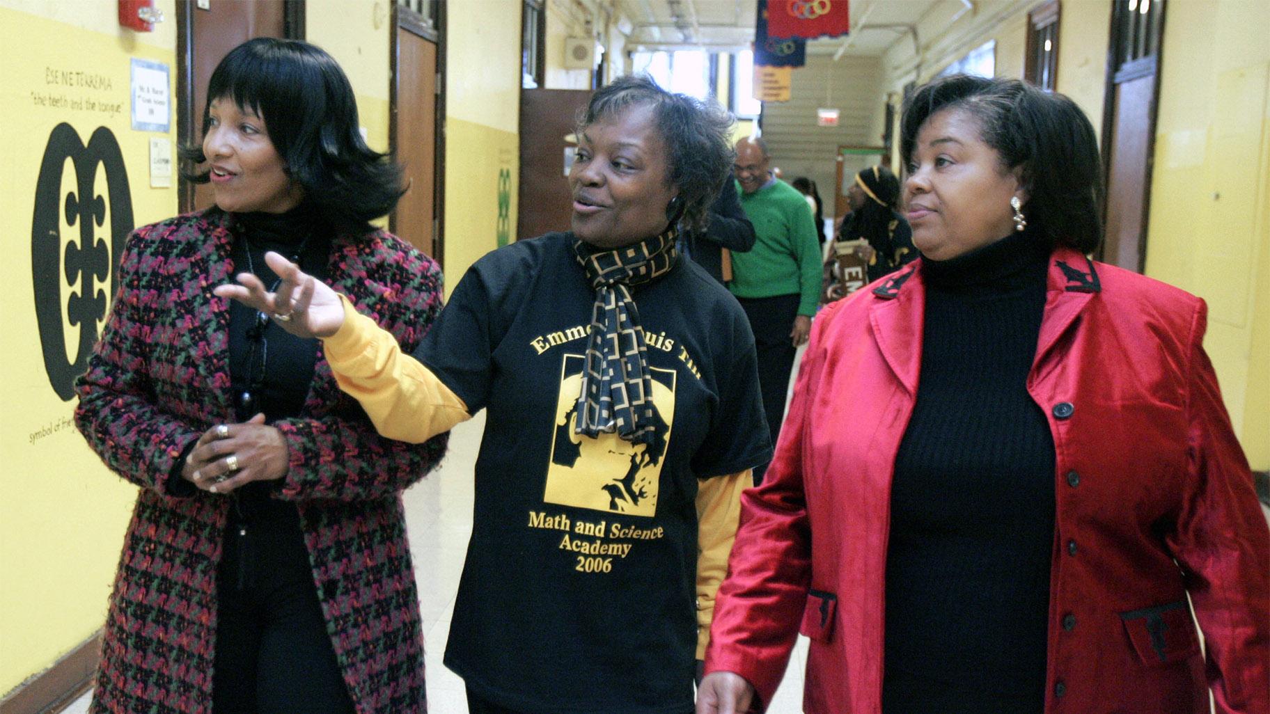 In this Feb 24, 2006, file photo, Deborah Watts, left, and Ollie Gordon, right, both cousins of Emmett Till, accompany Principal Mary Rogers as they walk through a hallway at Emmett Louis Till Math & Science Academy, in Chicago, honoring the 14-year-old former student. Till's lynching galvanized the civil rights movement. (AP Photo / M. Spencer Green, File)