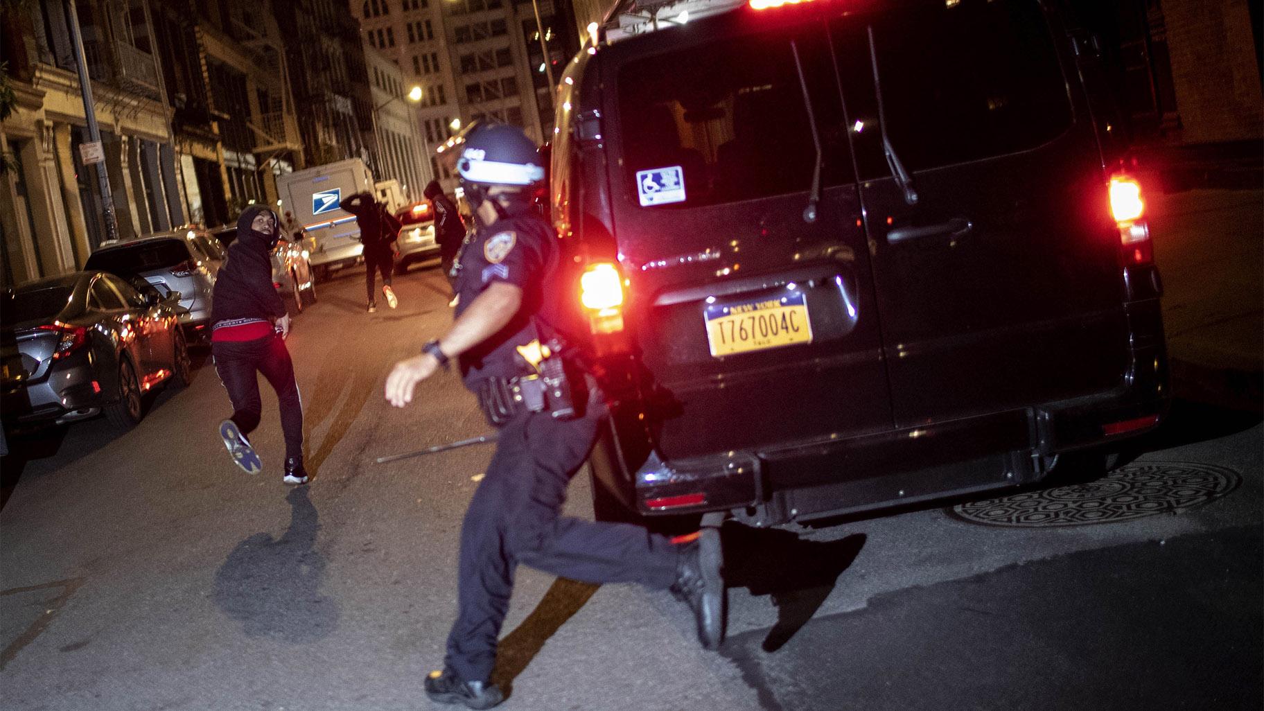 FILE - In this June 1, 2020, file photo, a protester runs as he is chased by police in New York. A grim video of a Chicago police officer fatally shooting a 13-year-old boy is once again shining a light on the policies that govern foot chases. (AP Photo / Wong Maye-E, File)