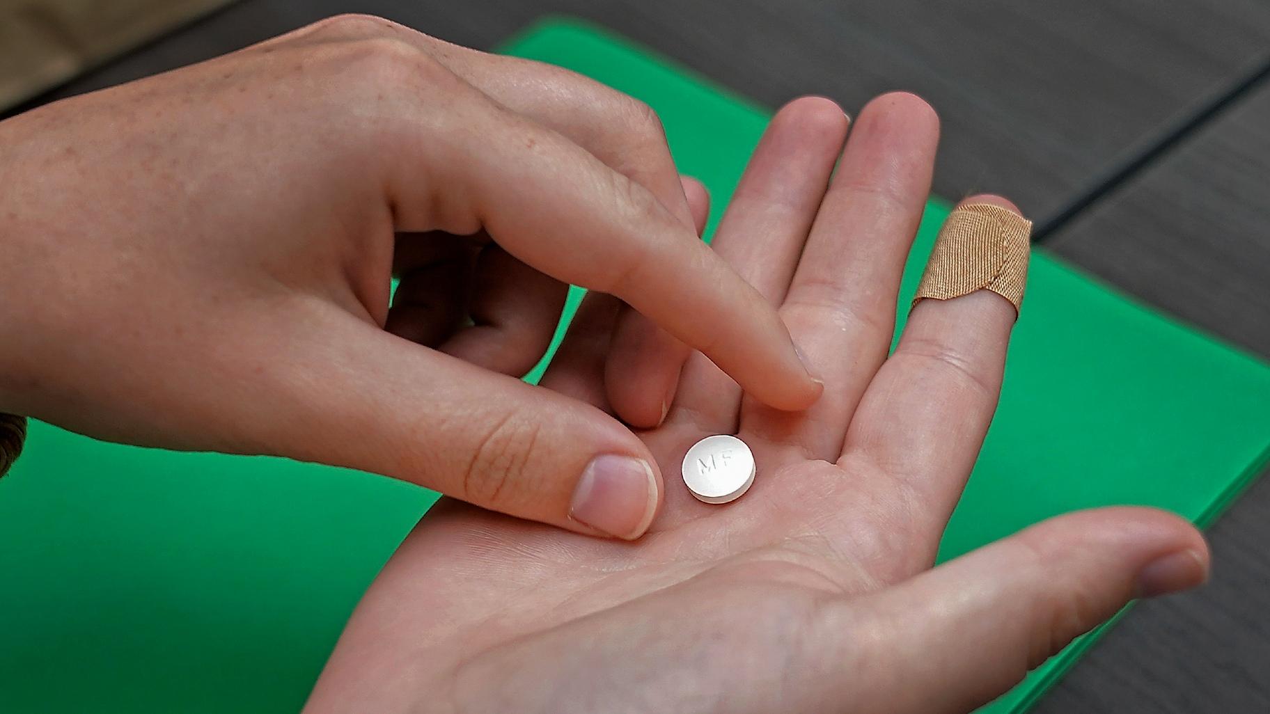 FILE - A patient prepares to take the first of two combination pills, mifepristone, for a medication abortion during a visit to a clinic in Kansas City, Kan., on, Oct. 12, 2022. (Charlie Riedel / AP Photo, File)
