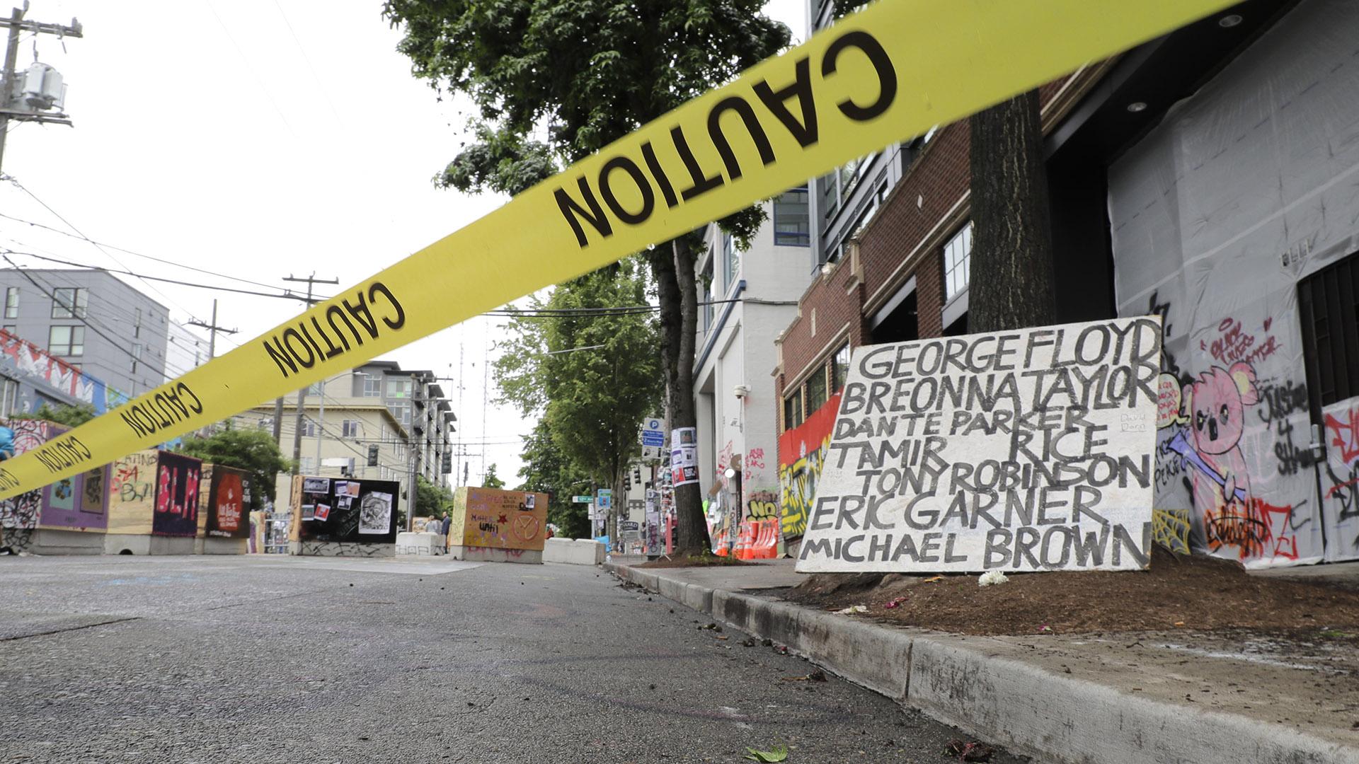 Caution tape is shown near a sign with the names of victims of police violence, Saturday, June 20, 2020, at the Capitol Hill Occupied Protest zone in Seattle. (AP Photo / Ted S. Warren)