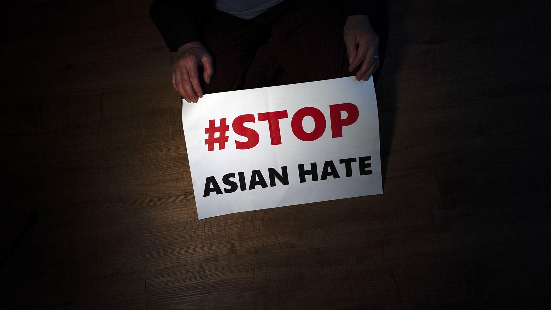In this March 31, 2021, file photo, Jen Ho Lee, a 76-year-old South Korean immigrant, poses in her apartment in Los Angeles with a sign from a recent rally against anti-Asian hate crimes she attended. (AP Photo / Jae C. Hong, File)