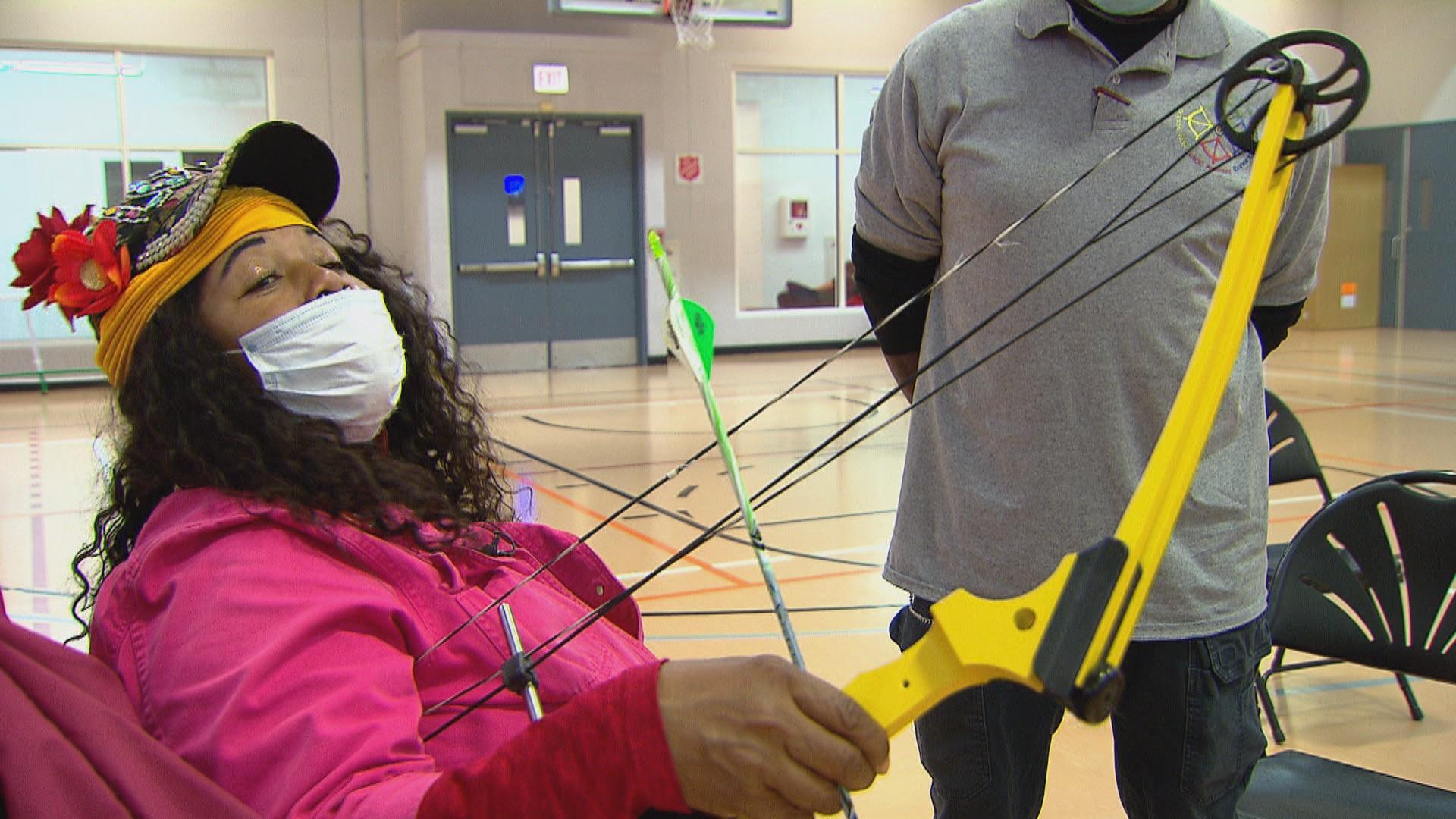 Babette Peyton demonstrates how she fits an arrow to a bowstring, an action called nocking in archery, at the Kroc Center Chicago on Nov. 19, 2020. (WTTW News)