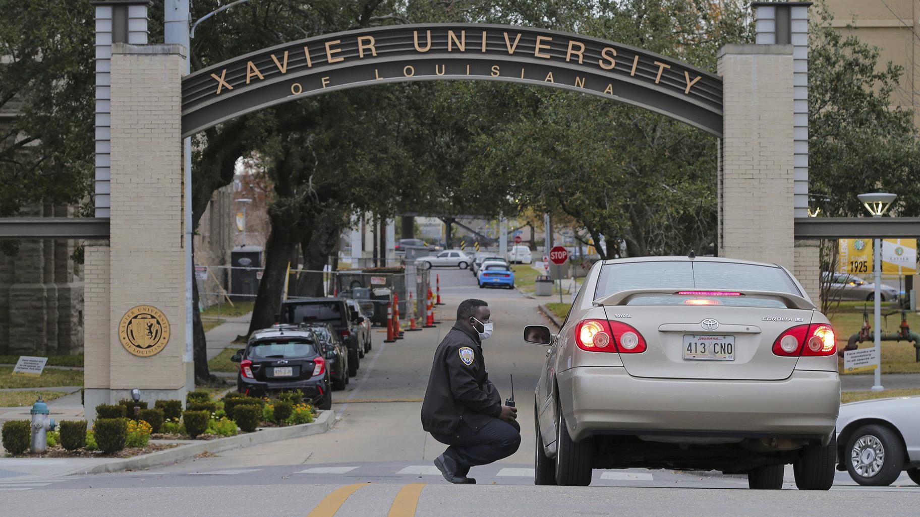A Xavier University police officer redirects a motorist around campus after a bomb threat put the campus on lockdown in New Orleans, La., Feb. 1, 2022. (David Grunfeld / The Advocate via AP, File)