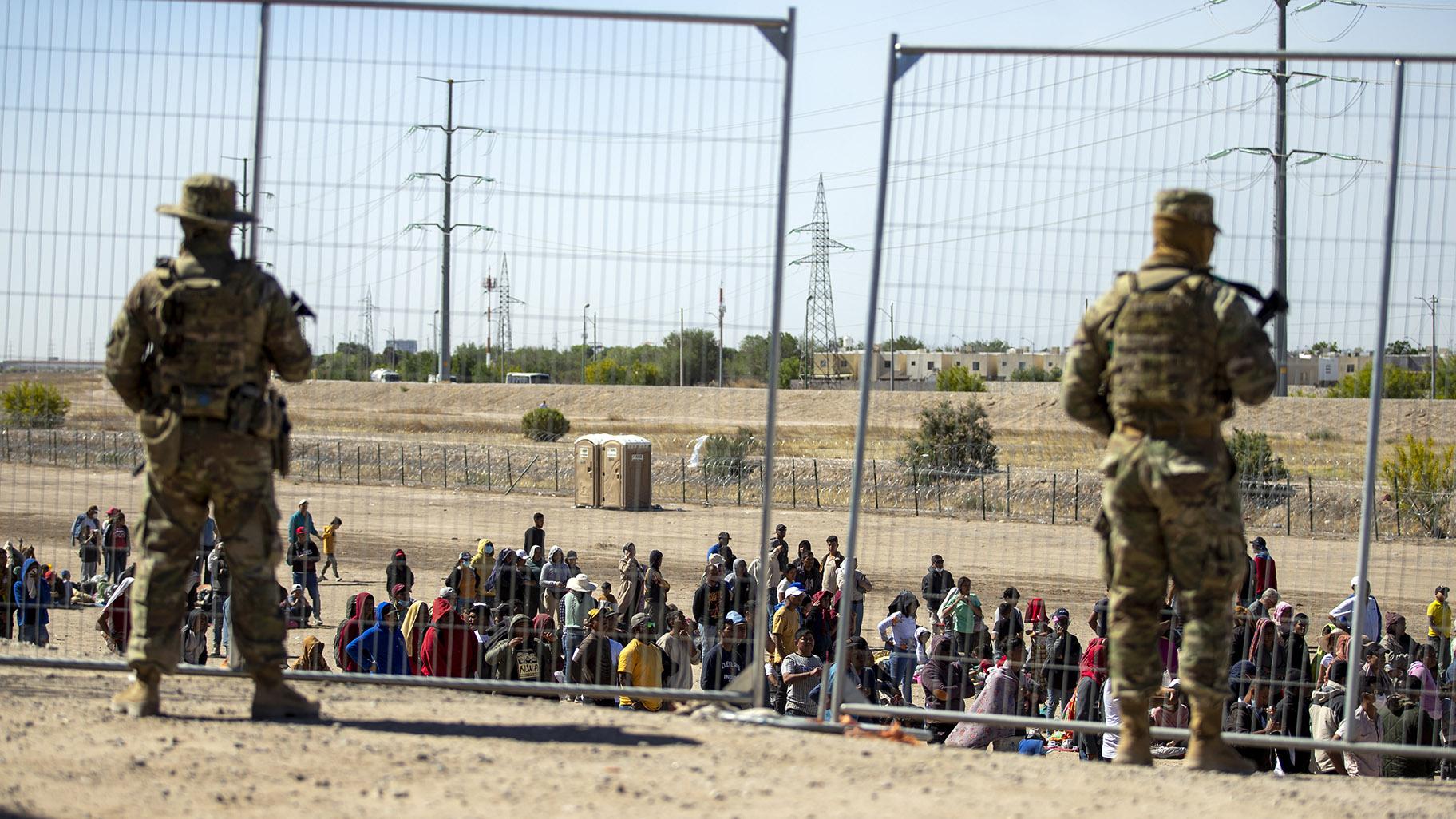 Migrants wait in line adjacent to the border fence under the watch of the Texas National Guard to enter into El Paso, Texas, Wednesday, May 10, 2023. (AP Photo / Andres Leighton, File)