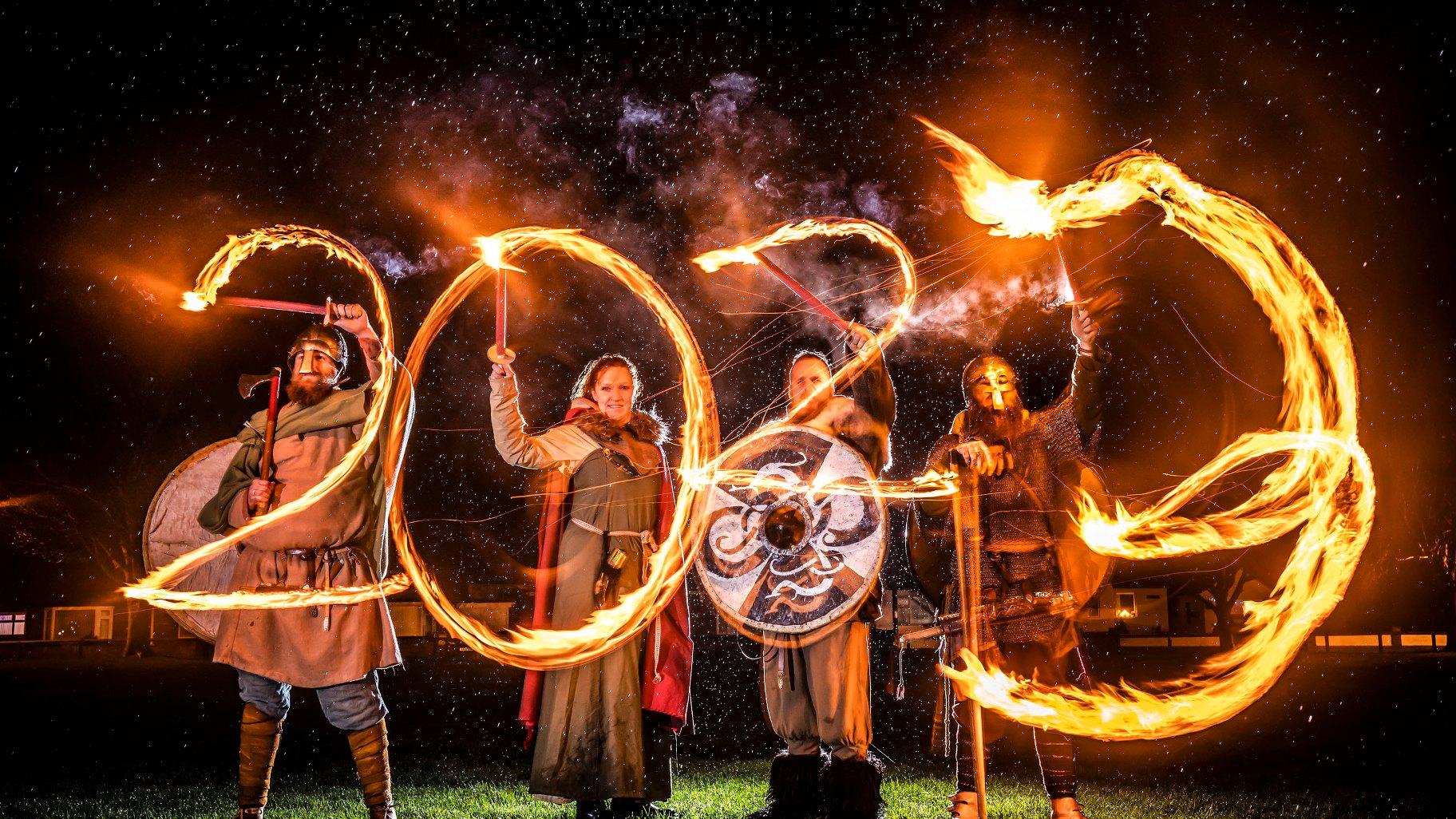 Viking reenactors use flaming torches to write 2023 at the Flamborough Fire Festival, a Viking themed parade in aid of charities and local community groups, held on New Year's Eve in Flamborough near Bridlington, England, Saturday Dec. 31, 2022. (Danny Lawson/PA via AP)