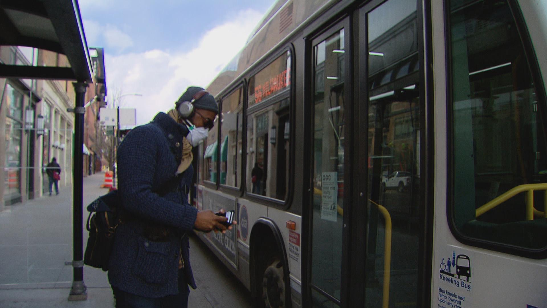 A person wearing a face mask boards a CTA bus in Chicago. (WTTW News)