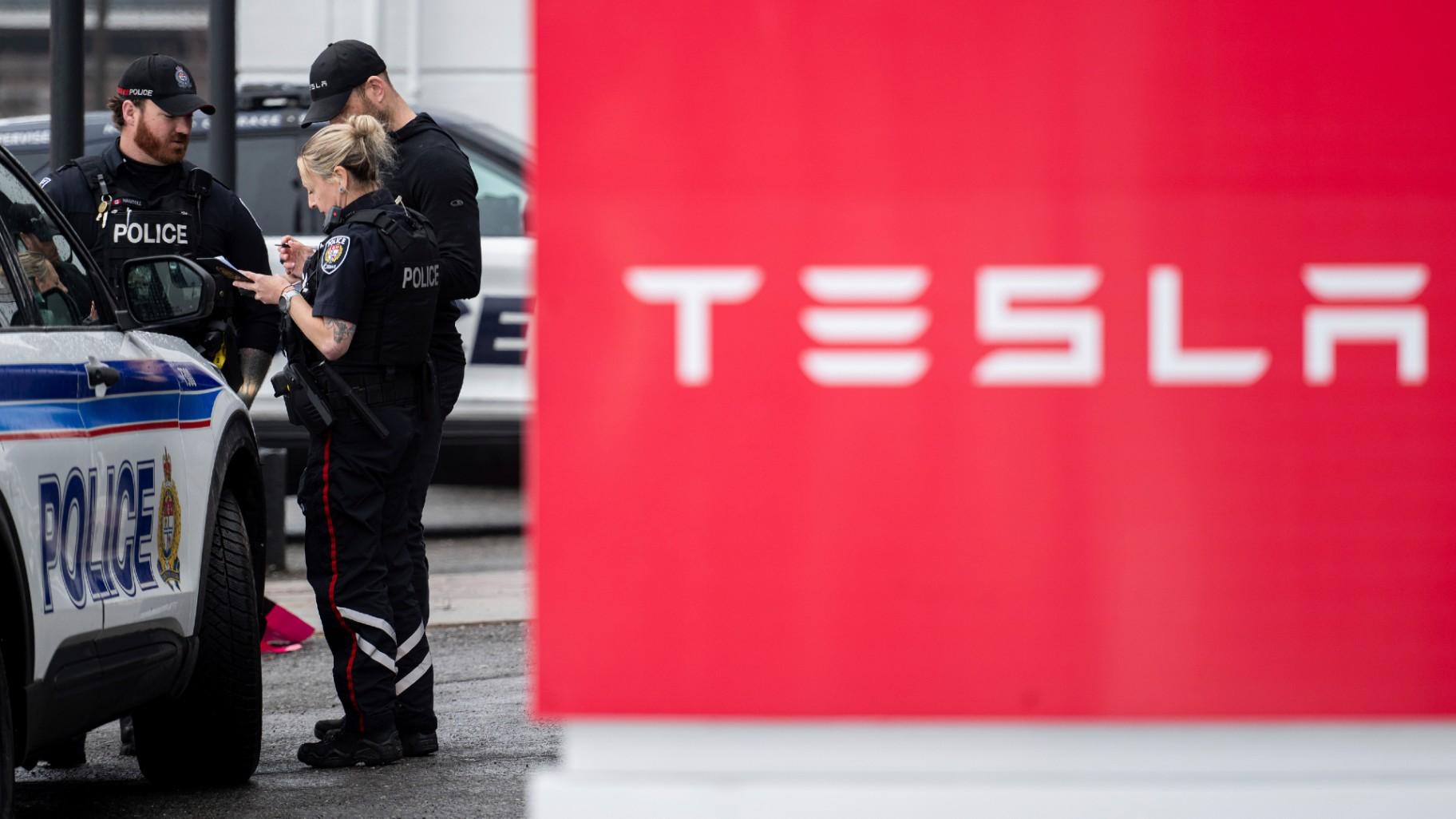 Officers from Ottawa Police Service (OPS) are seen at a Tesla Service and Showroom centre after it was damaged with pink spray paint in Ottawa, on Monday, March 31, 2025. (Spencer Colby / The Canadian Press via AP)