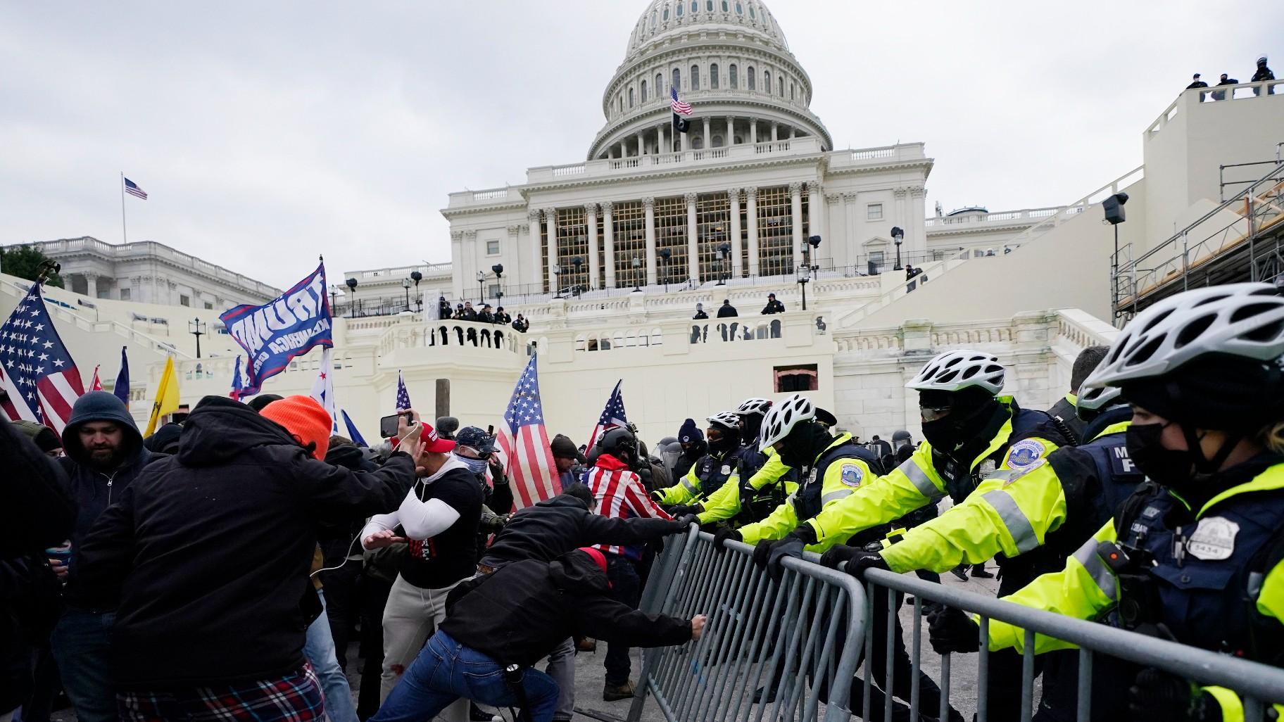 Rebels loyal to President Donald Trump try to breach a police barrier in the Capitol, Washington, Wednesday, January 6, 2021.  (AP Photo/Julio Cortez, FILE)