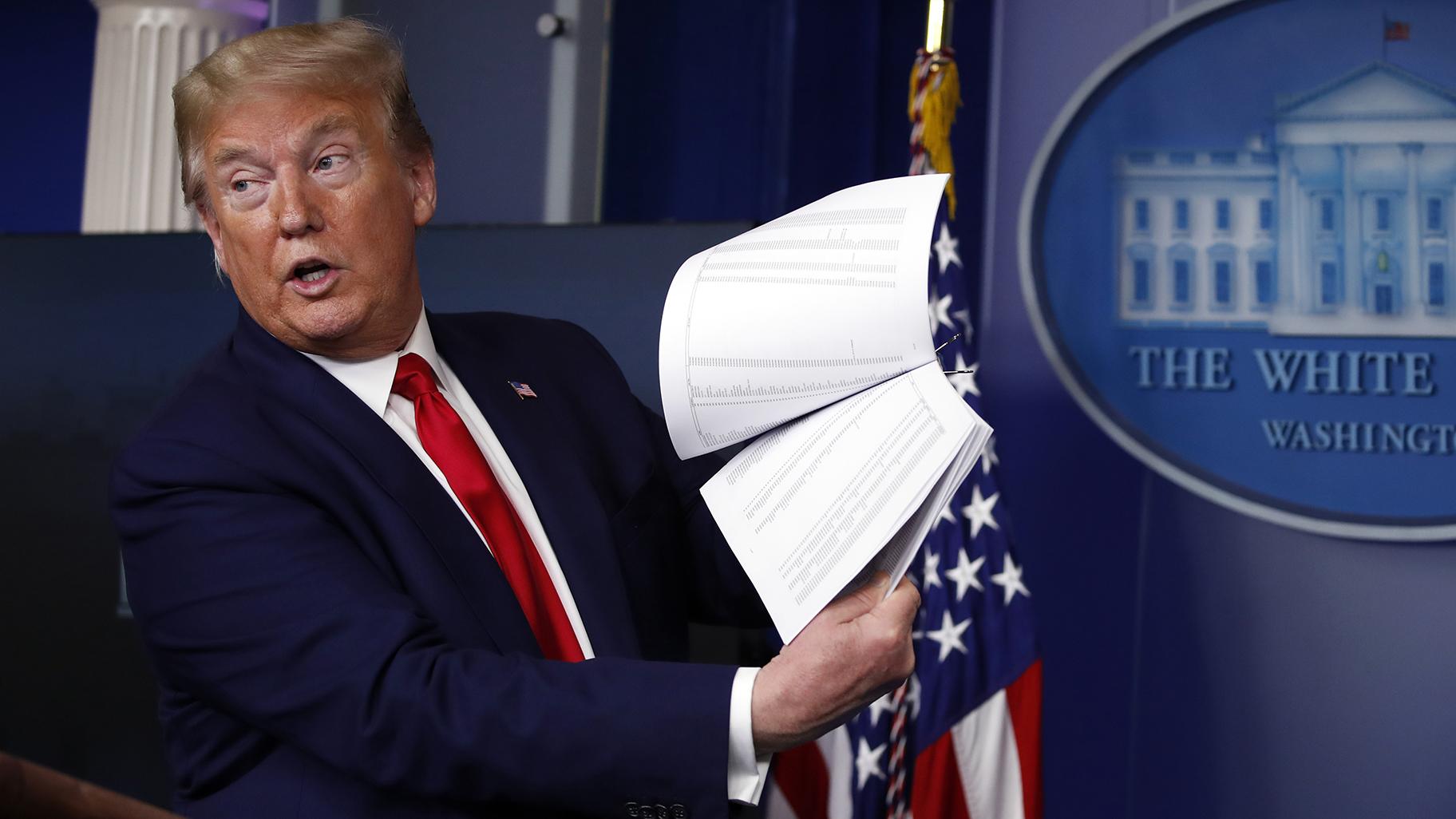 President Donald Trump holds up papers as he speaks about the coronavirus in the James Brady Press Briefing Room of the White House on April 20, 2020, in Washington. (AP Photo / Alex Brandon, File)