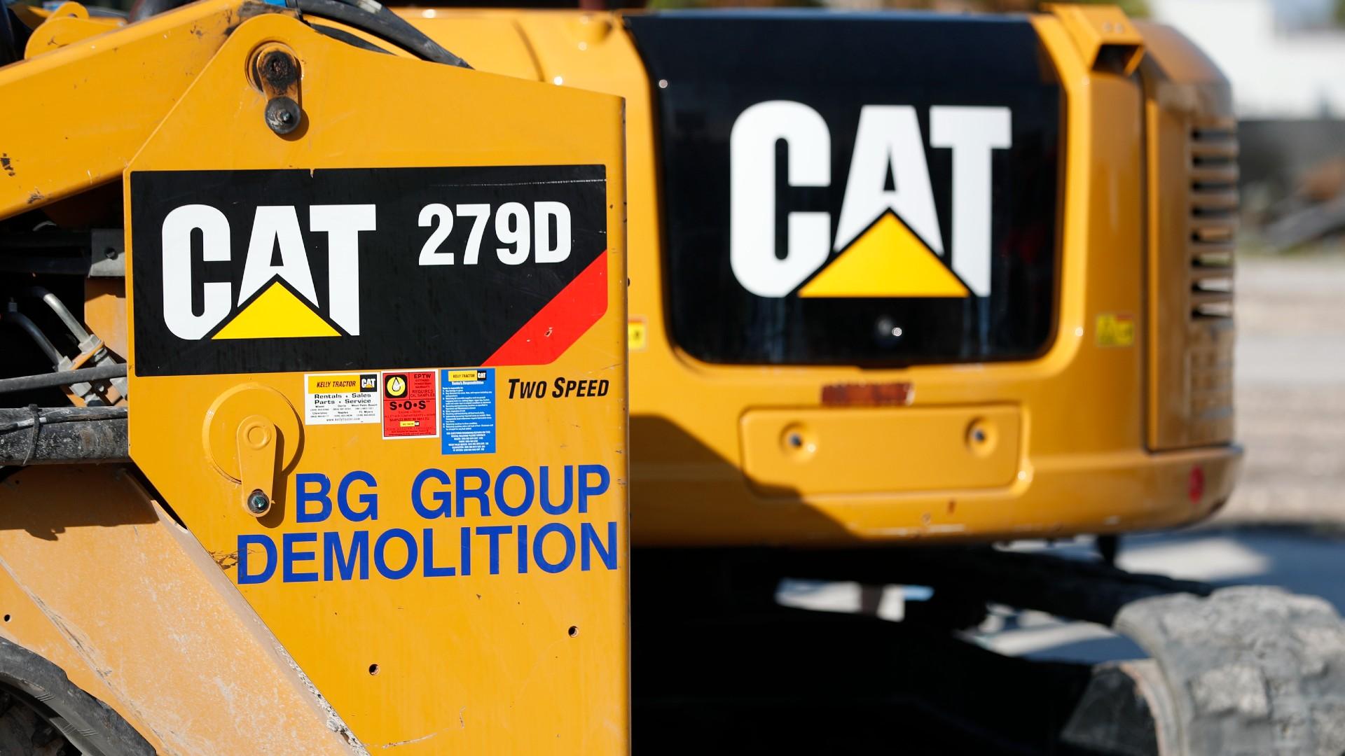 This May 8, 2019 photo shows a Caterpillar 279D Compact Track Loader, left, and 308E2 CR Mini Hydraulic Excavator, right, rear, at a demolition site in Fort Lauderdale, Fla. (AP Photo / Wilfredo Lee, File)