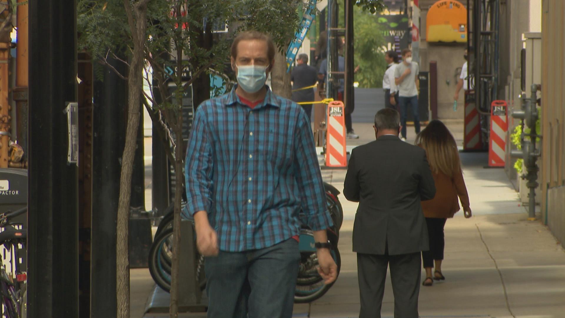 People wearing face masks walk along a street in downtown Chicago on Sept. 2, 2020. Officials concerned about the possibility for a spike in COVID-19 infections over the Labor Day weekend are reminding residents to wear masks and practice social distancing. (WTTW News)