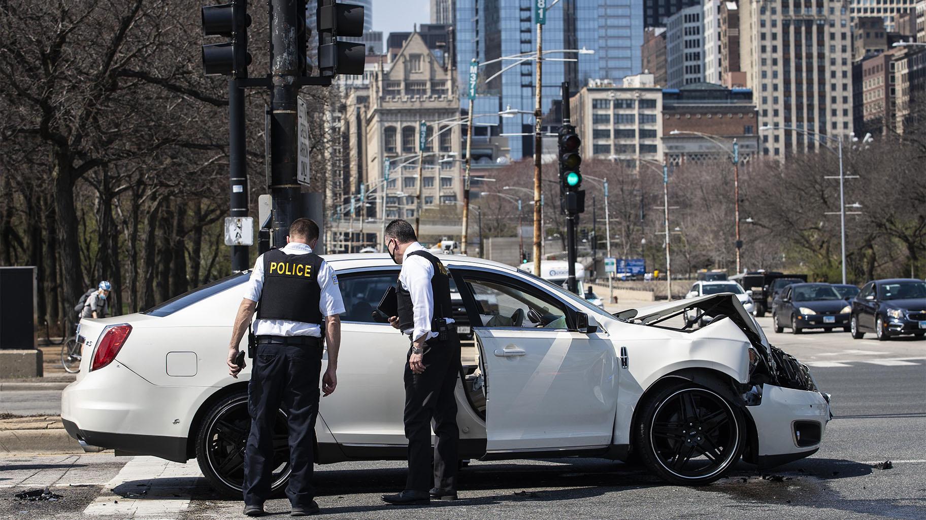 Chicago police investigate in the northbound lanes of Lake Shore Drive at East Monroe Street, where a 2-year-old boy was shot in the head while he was traveling inside a car near Grant Park, Tuesday, April 6, 2021. (Ashlee Rezin Garcia / Chicago Sun-Times via AP)