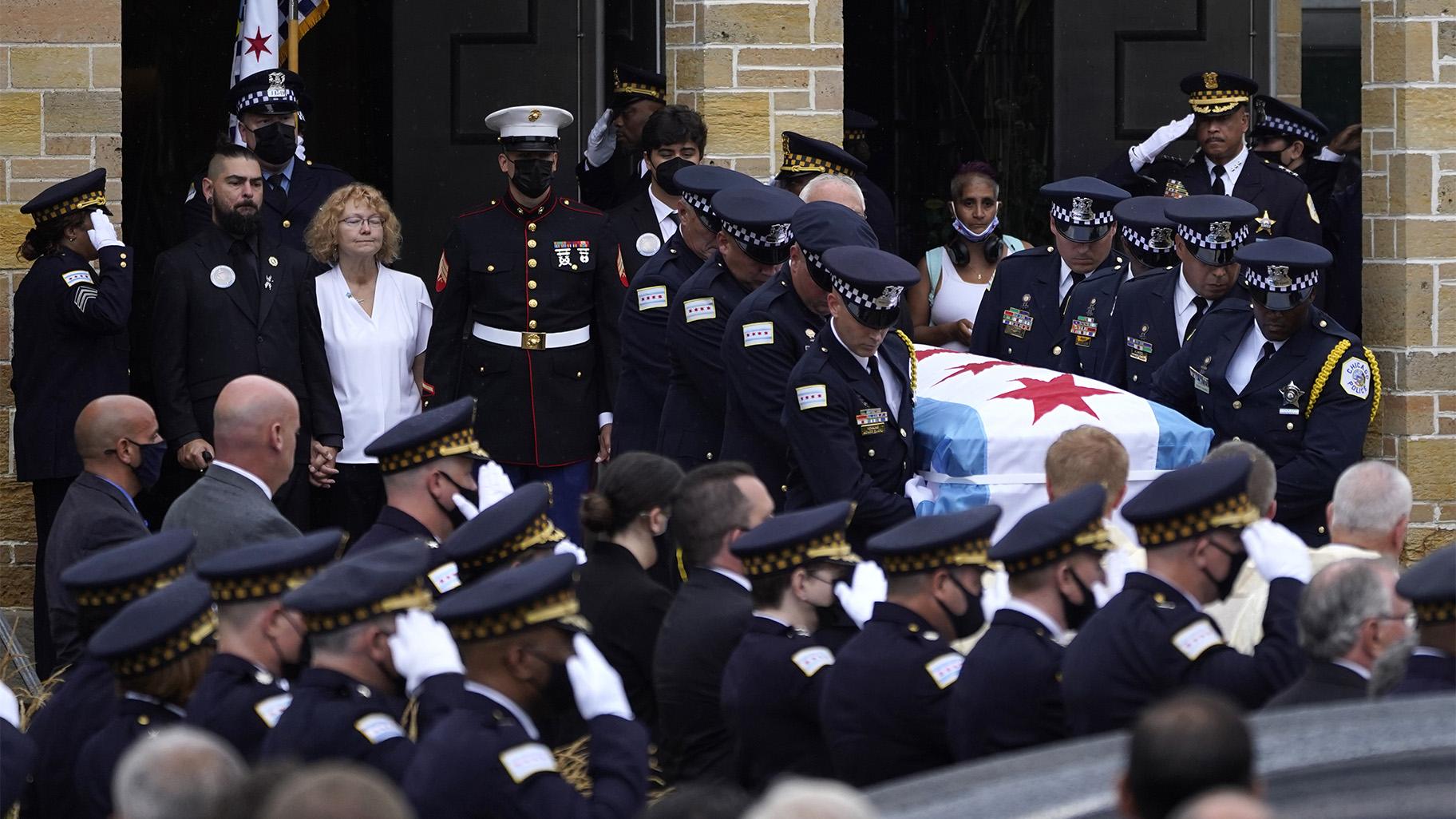 Elizabeth French, in white, and her son Andrew, left, follow the casket of her daughter, Chicago police officer Ella French, after a funeral service at the St. Rita of Cascia Shrine Chapel Thursday, Aug. 19, 2021, in Chicago.   (AP Photo / Charles Rex Arbogast, File)