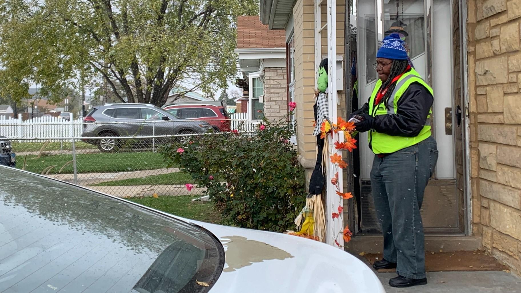 Community health worker Stefferina Woodrick leaving a flyer at a house on the 7800-block of Pulaski Road in Ashburn on Oct. 31, 2023. (Eunice Alpasan / WTTW News)