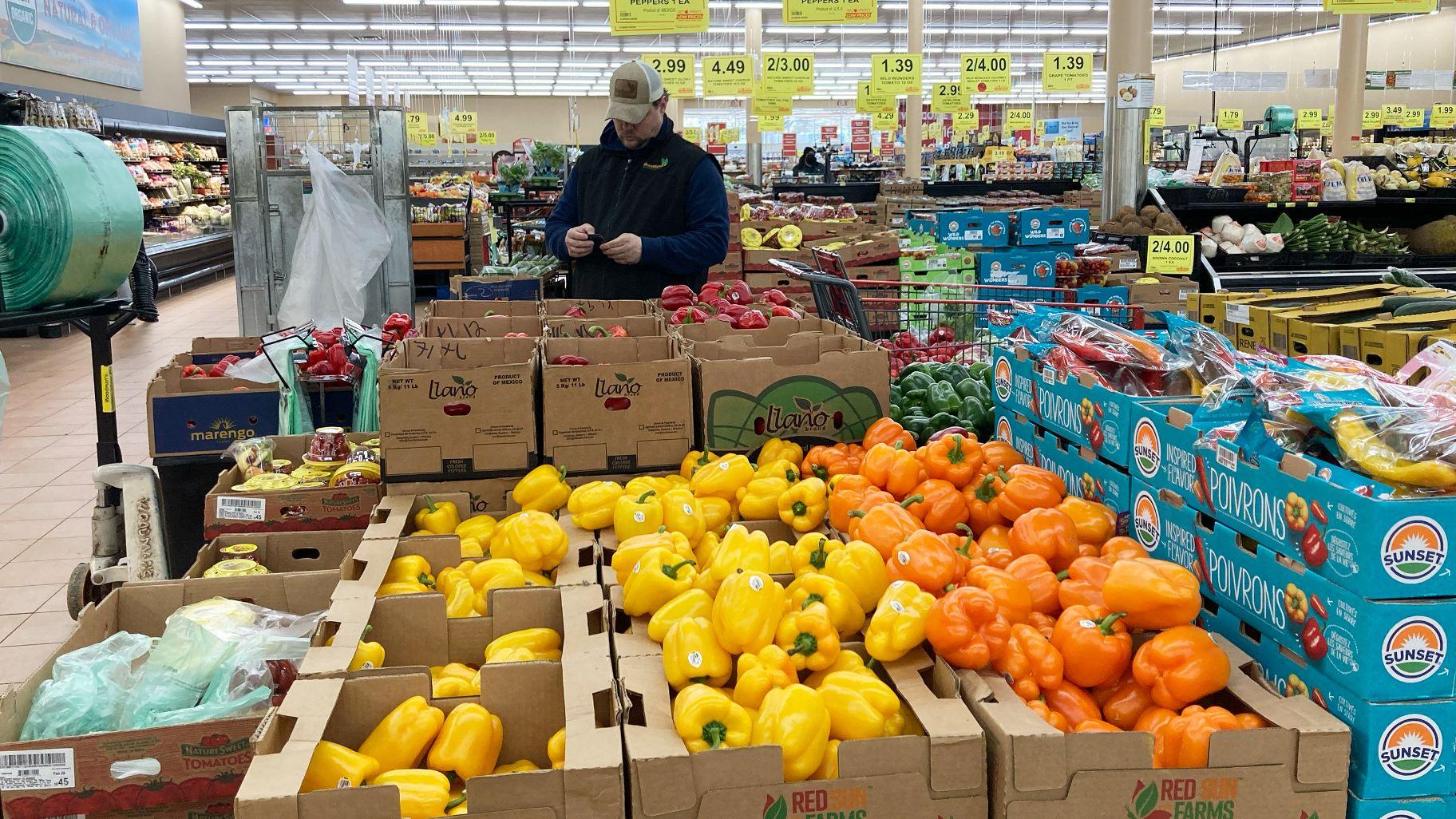 A man looks at his mobile phone while shopping at a grocery store in Buffalo Grove, Ill., Sunday, March 19, 2023. On Wednesday, the Labor Department reports on U.S. consumer prices for March. (AP Photo / Nam Y. Huh)