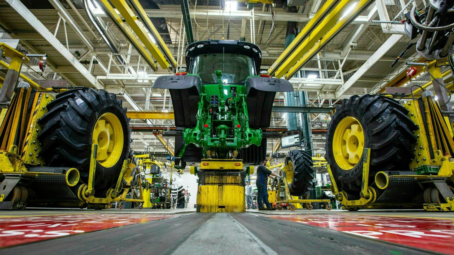 In this April 9, 2019, wheels are attached as workers assemble a tractor at John Deere's Waterloo, Iowa assembly plant. (Zach Boyden-Holmes / Telegraph Herald via AP, File)