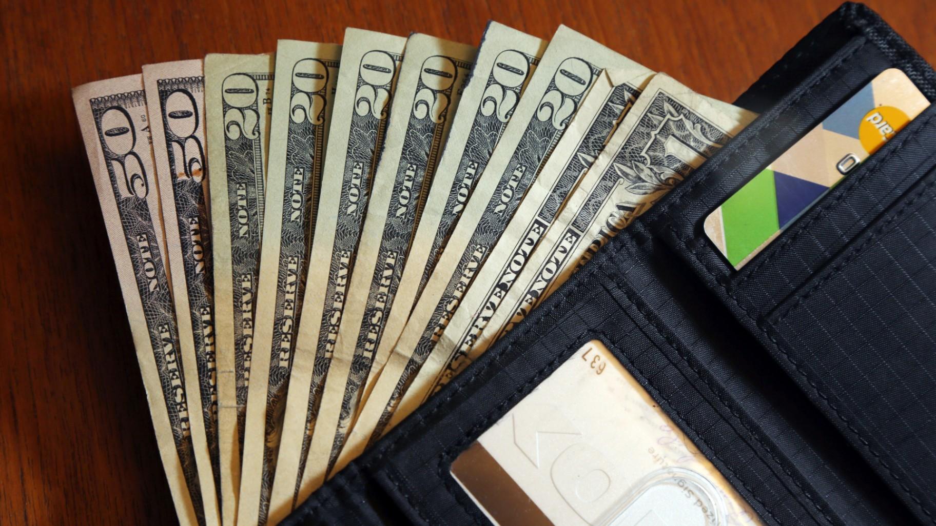 In this June 15, 2018, file photo, cash is fanned out from a wallet in North Andover, Mass. (AP Photo / Elise Amendola, File)