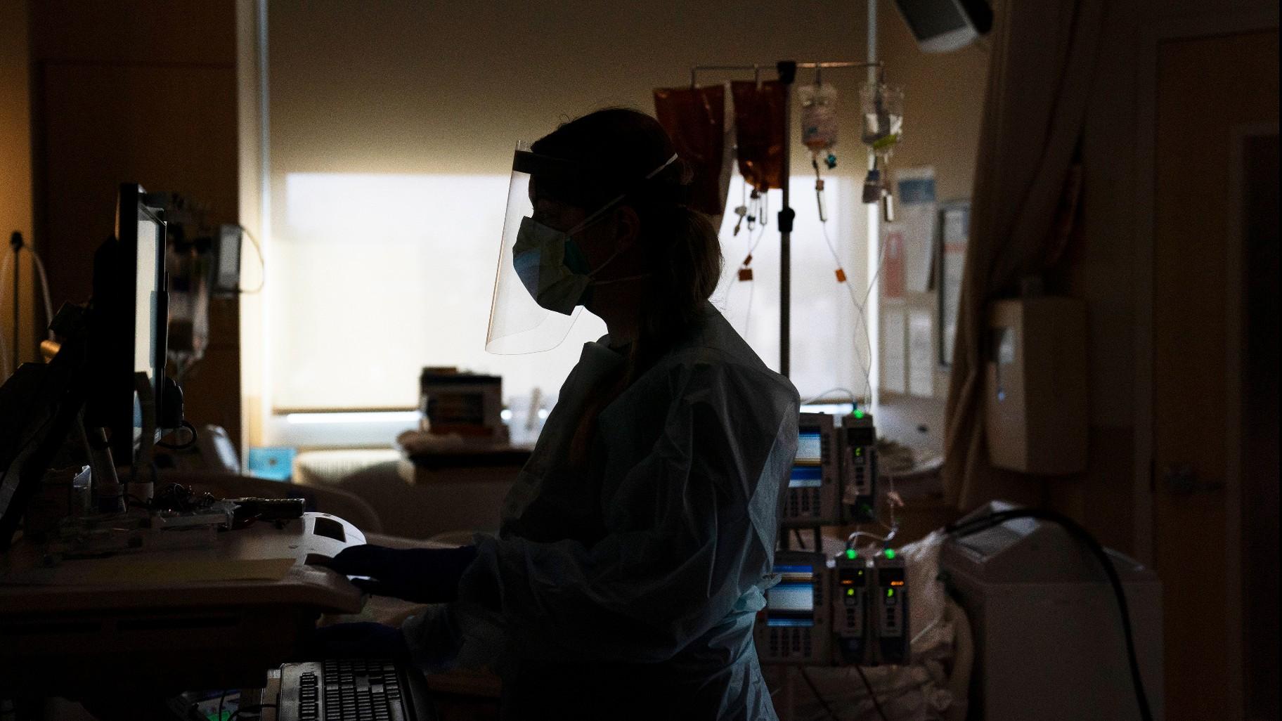  A registered nurse works on a computer while assisting a COVID-19 patient in Los Angeles. (AP Photo / Jae C. Hong, File)