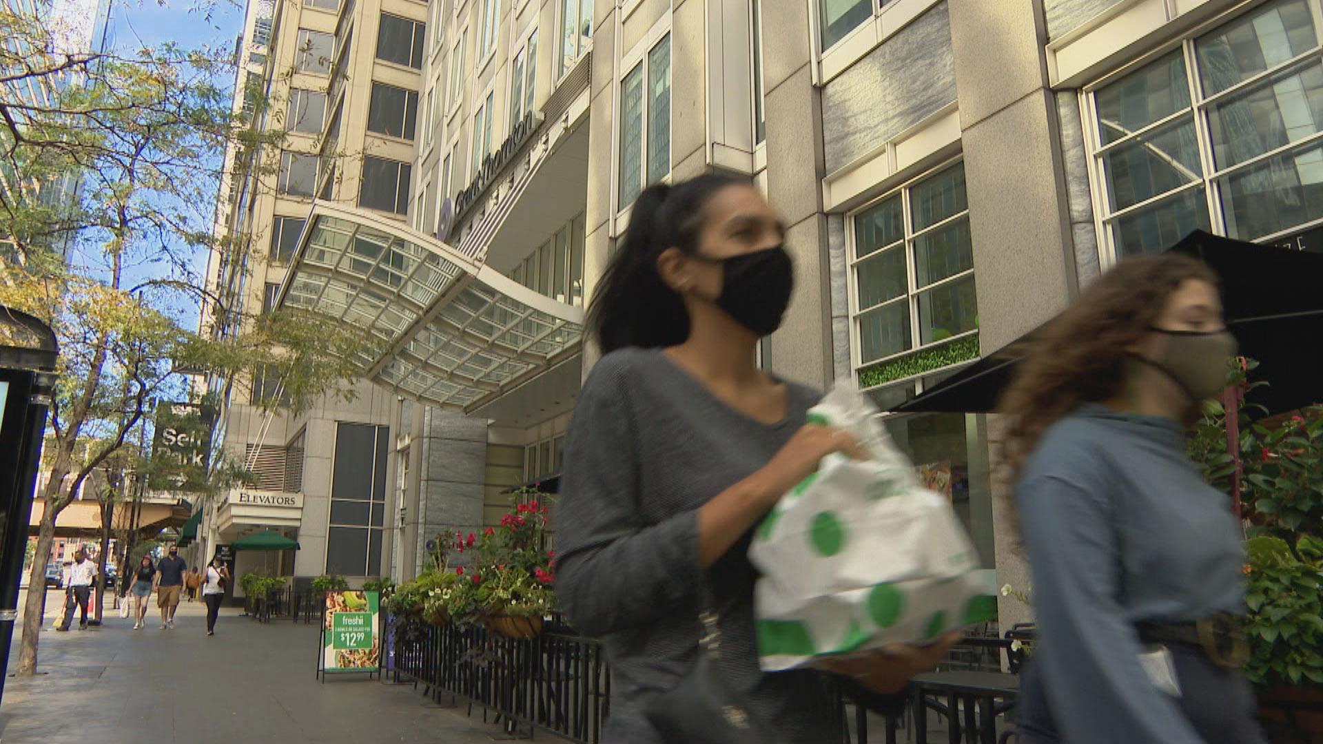 People wearing face masks walk along a street in downtown Chicago on Sept. 2, 2020. (WTTW News)