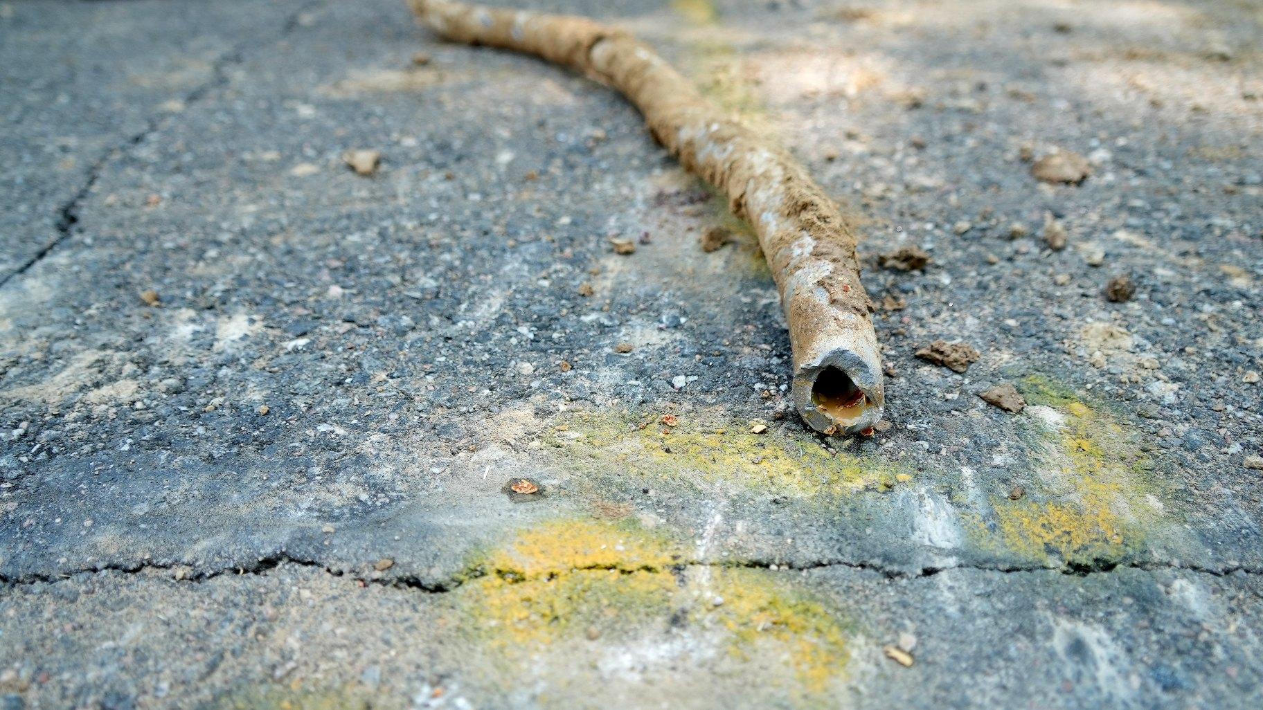 A lead water service line from 1927 lays on the ground on a residential street after being removed on June 17, 2021, in Denver. (AP Photo / Brittany Peterson, File)