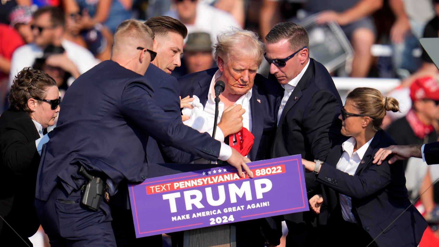 Republican presidential candidate former President Donald Trump is helped off the stage at a campaign event in Butler, Pa., Saturday, July 13, 2024. (AP Photo/Gene J. Puskar)