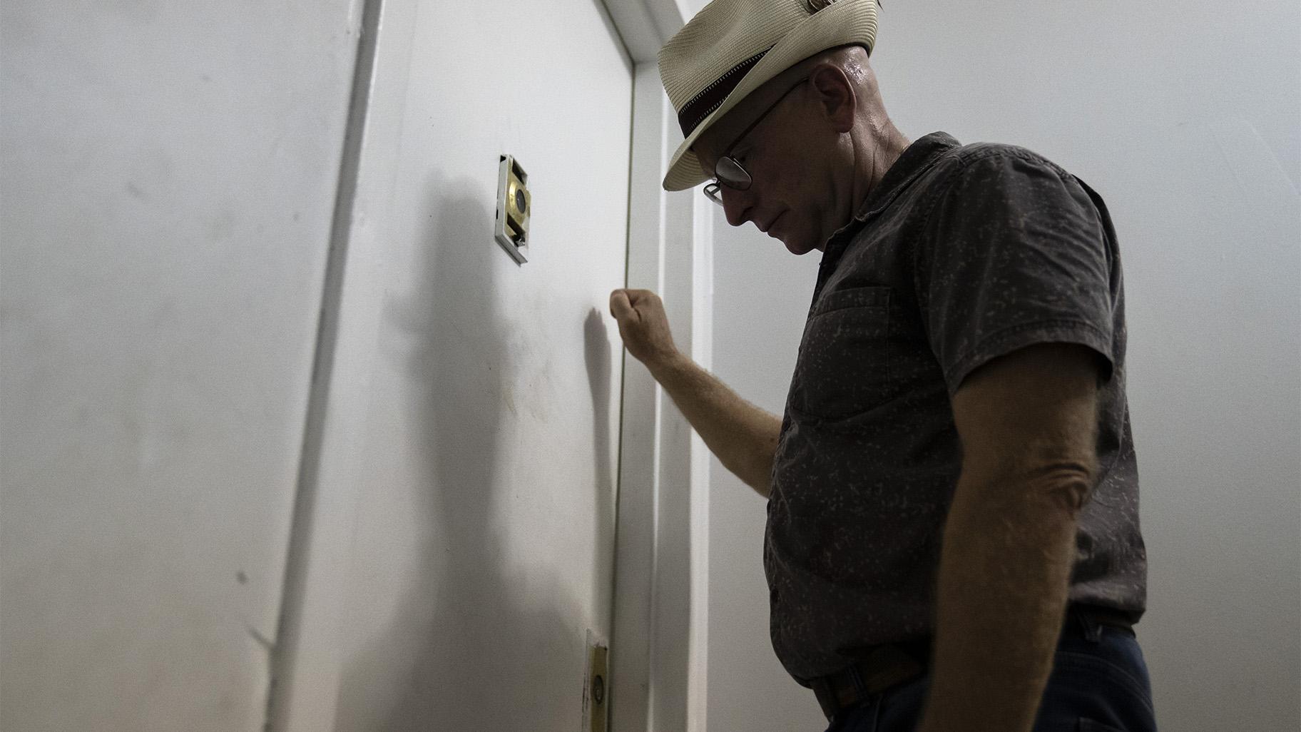 Gary Zaremba knocks on an apartment door as he checks in with tenants to discuss building maintenance at one of his at properties, Thursday, Aug. 12, 2021, in the Queens borough of New York. (AP Photo / John Minchillo)