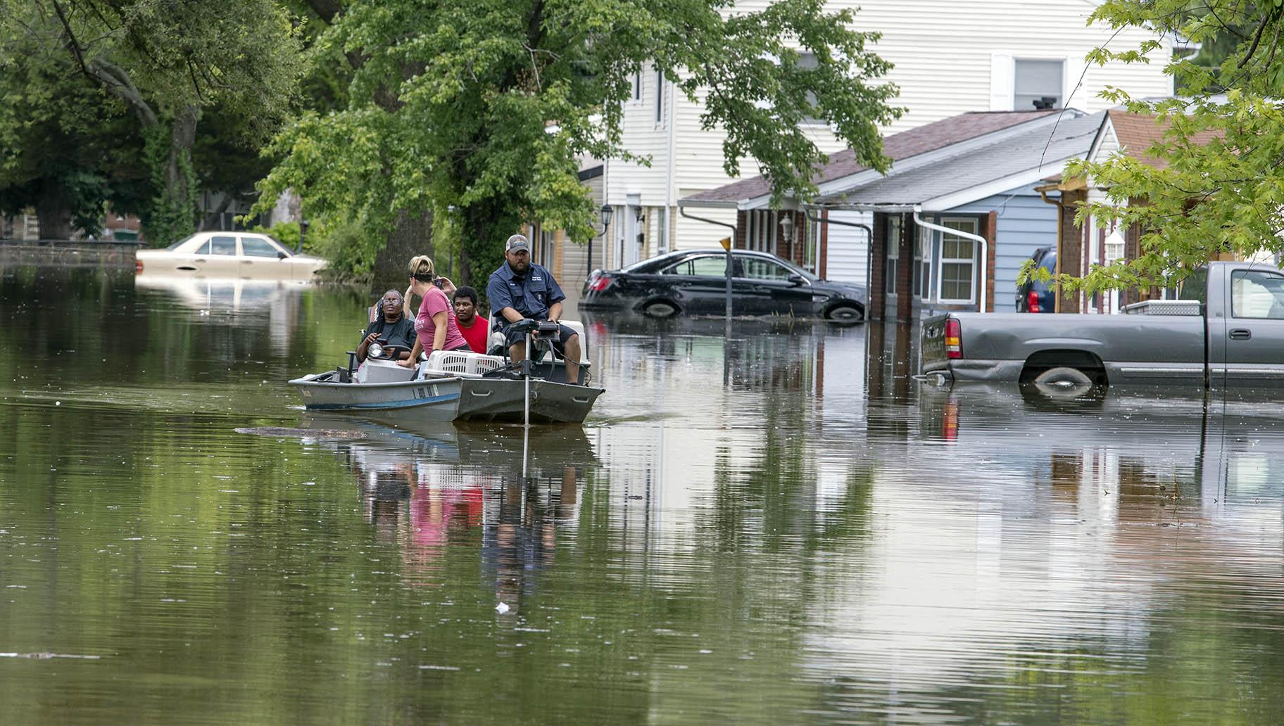 Gateway Pet Guardians use a boat to help pet owners rescue two cats and a dog from their home on Terrace Dr. in East St. Louis, Ill. Thursday afternoon July 28, 2022. (Derik Holtmann / Belleville News-Democrat via AP)