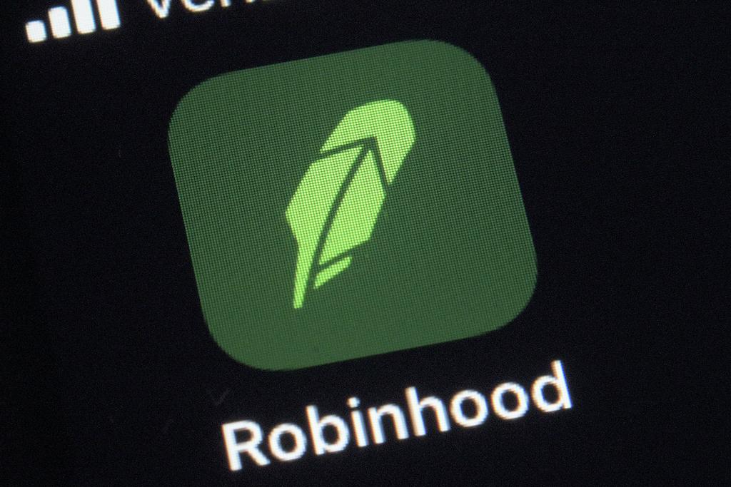 This Dec. 17, 2020 file photo shows the logo for the Robinhood app on a smartphone in New York. The online trading platform Robinhood is moving to restrict trading in GameStop and other stocks that have soared recently due to rabid buying by smaller investors. (AP Photo/Patrick Sison)