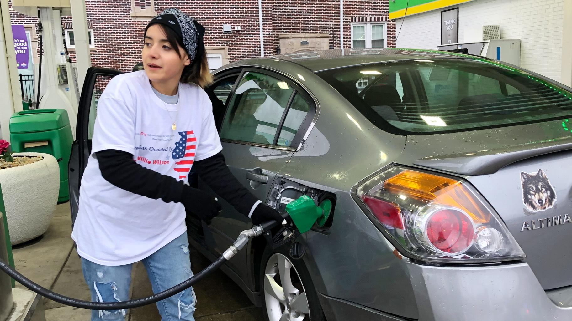 Volunteer Marissa Medina pumps gas at a BP station at Irving Park Road and Western Avenue during a giveaway, March 24, 2022. (Patty Wetli / WTTW News) 