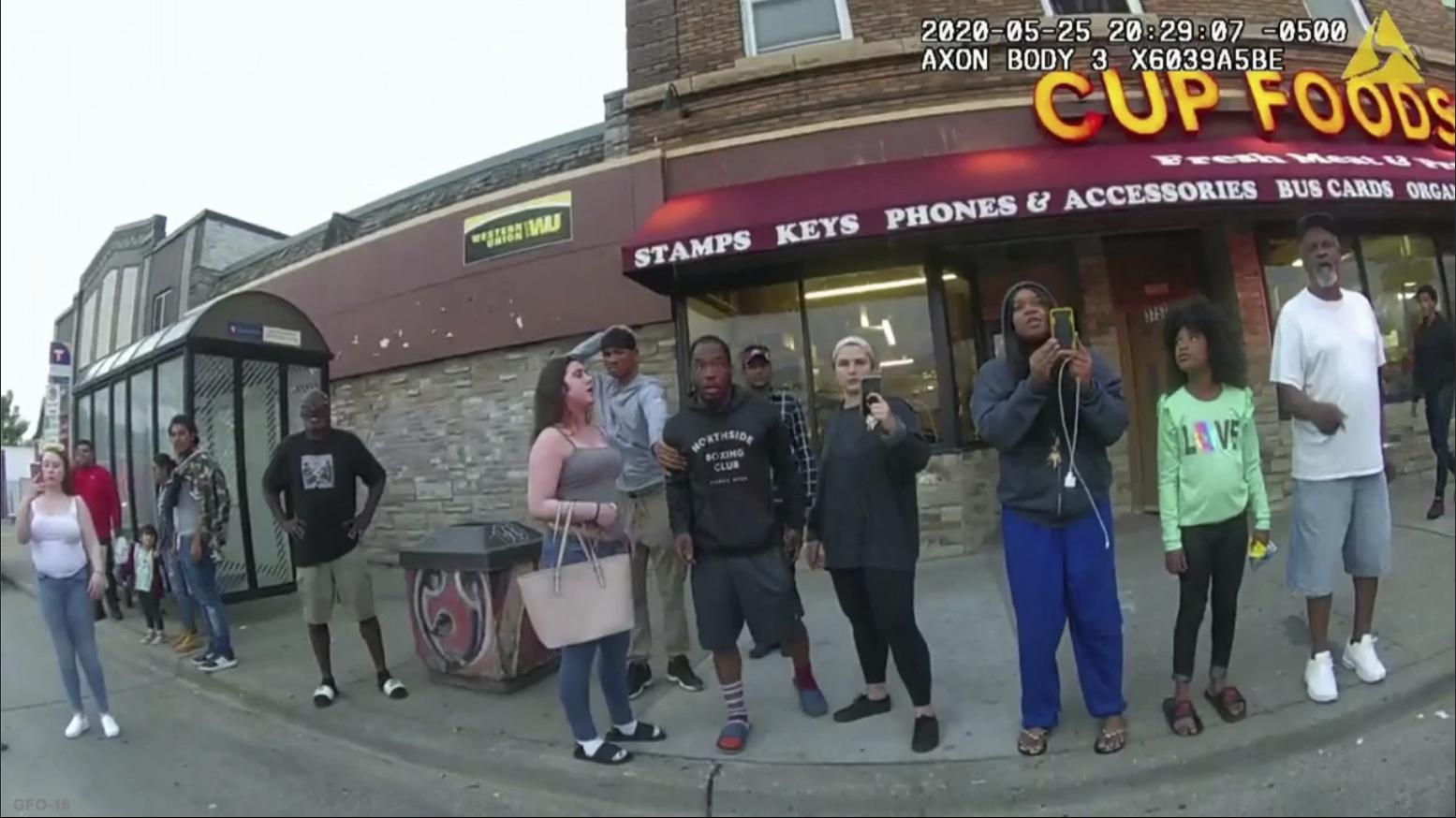 This image from a police body camera shows people gathering as former Minneapolis police officer Derek Chauvin was recorded pressing his knee on George Floyd’s neck for several minutes as onlookers yelled at Chauvin to get off and Floyd saying that he couldn’t breathe on May 25, 2020 in Minneapolis. (Minneapolis Police Department via AP)