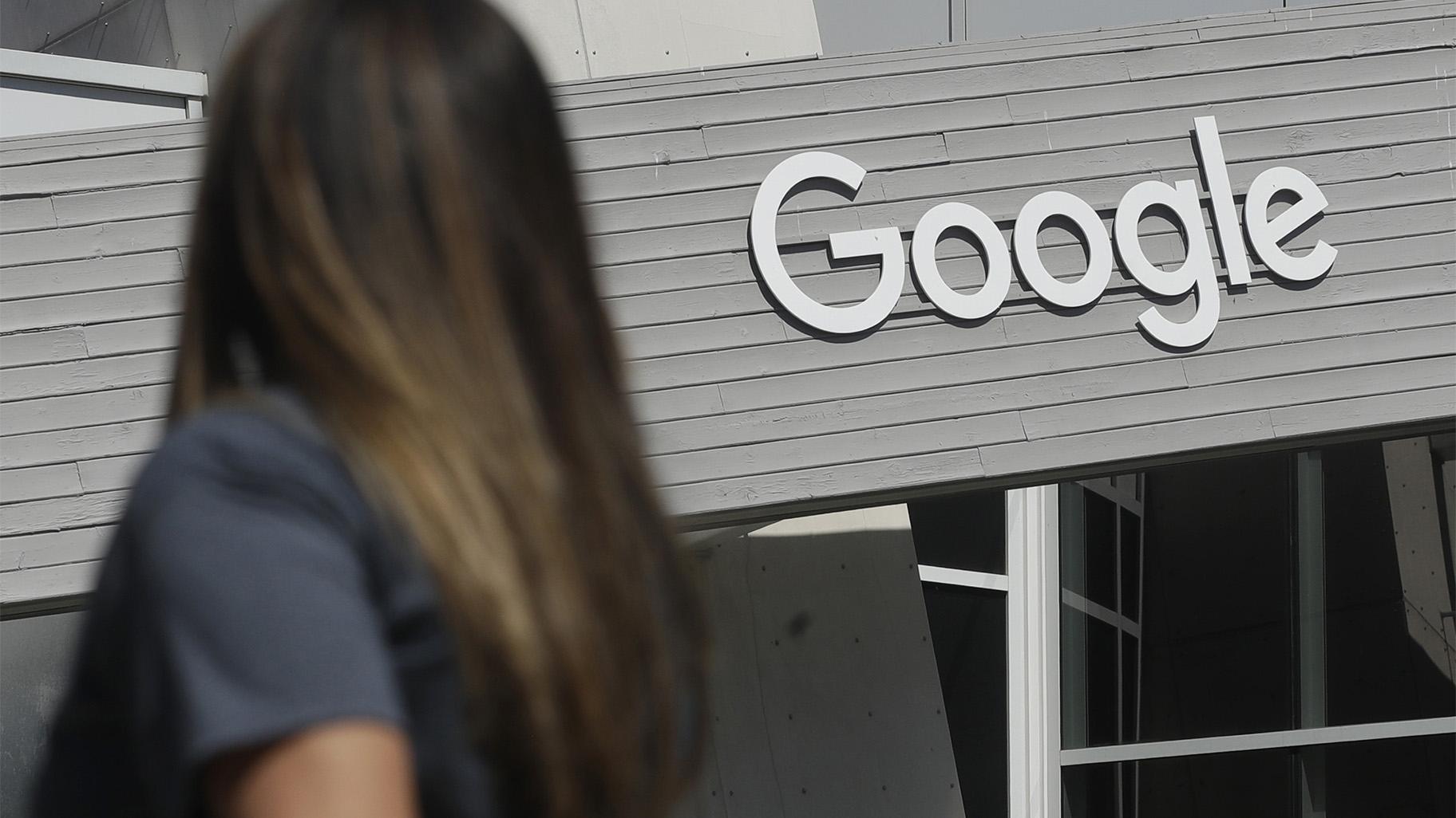 In this Sept. 24, 2019, file photo, a woman walks below a Google sign on the campus in Mountain View, Calif. (AP Photo / Jeff Chiu, File)