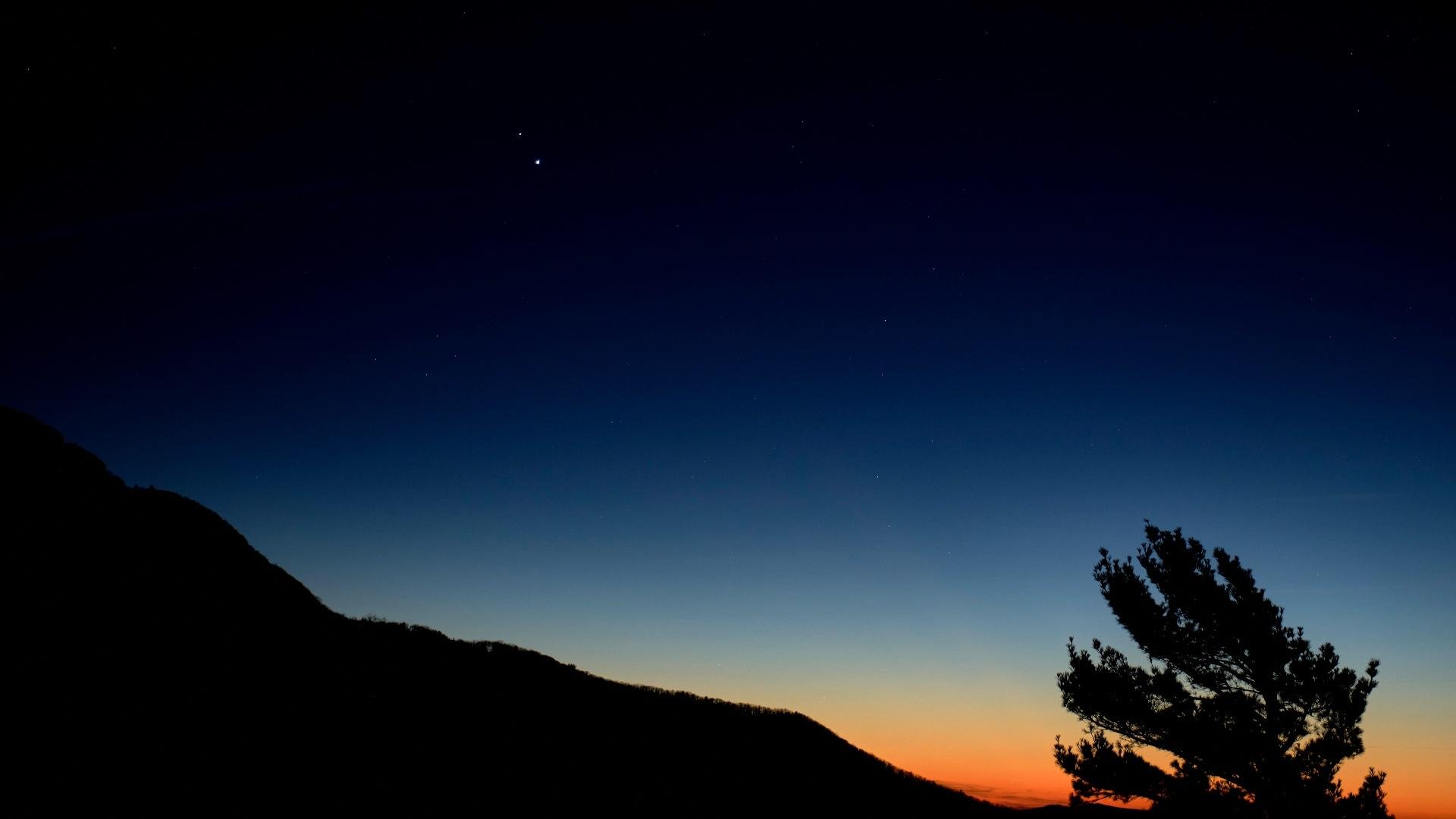 A photo taken on Dec. 13, 2020, shows Jupiter (the bright "star" on the right) closing in on Saturn to the left. (Bill Ingalls / NASA)