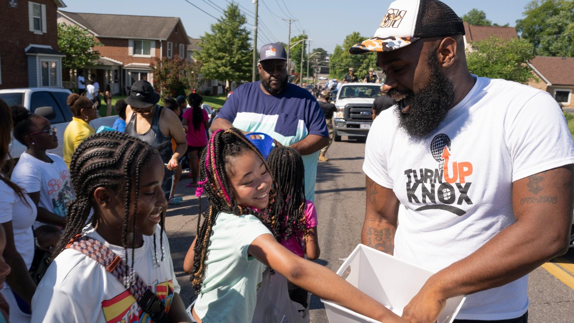 Quientest Vinson, right, of Turn Up Knox hands out candy to children during the Lonsdale Neighborhood Homecoming celebration Saturday, Aug. 5, 2023 in Knoxville, Tenn. (AP Photo / George Walker IV)