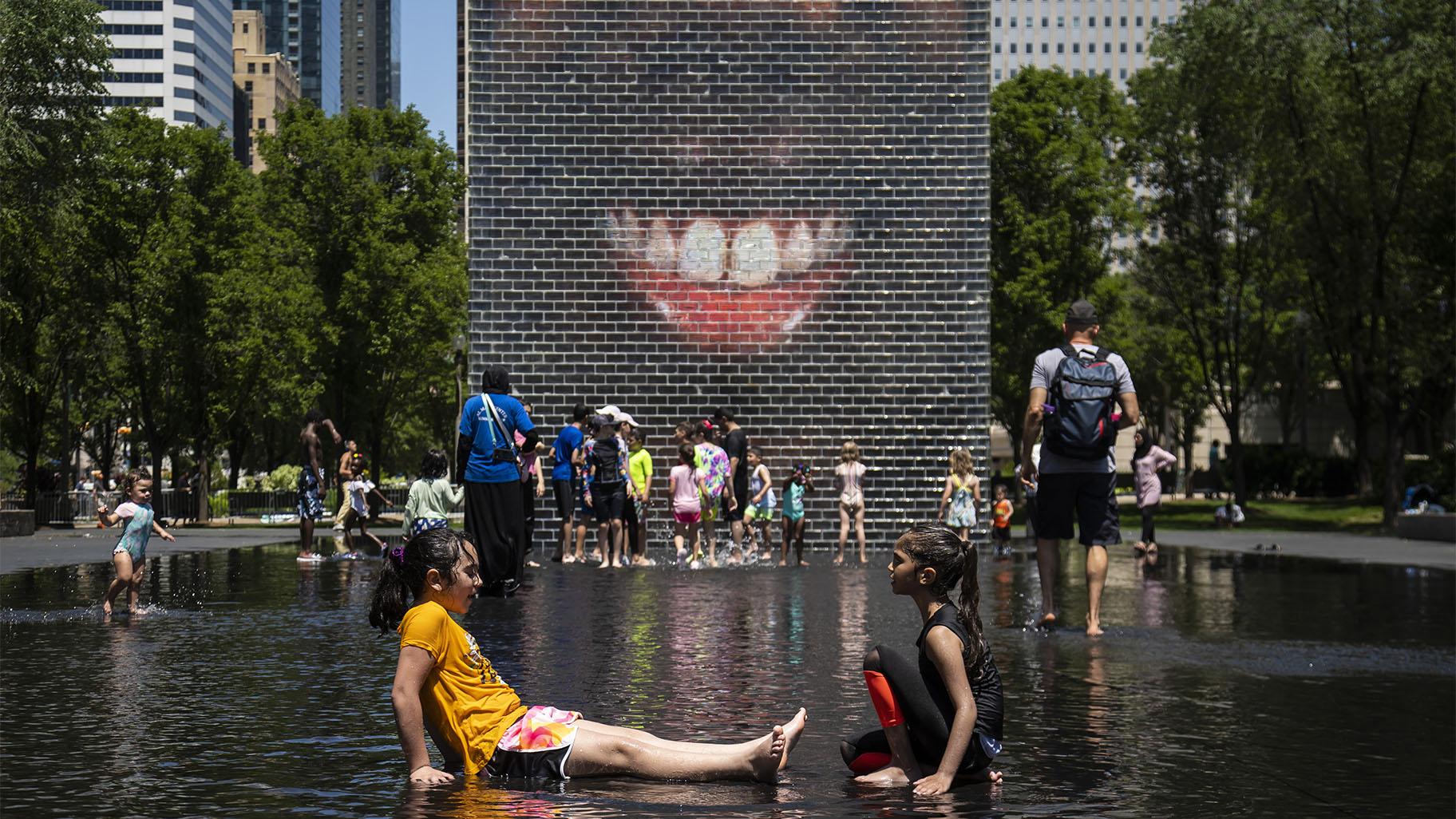 Children play in the Crown Fountain on Michigan Avenue, Tuesday afternoon, June 14, 2022, in Chicago. (Ashlee Rezin / Chicago Sun-Times via AP)