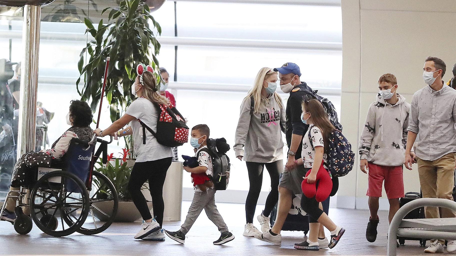 Travelers walk through Terminal A at Orlando International Airport on Christmas Day, Saturday, Dec. 25, 2021. (Stephen M. Dowell / Orlando Sentinel via AP)