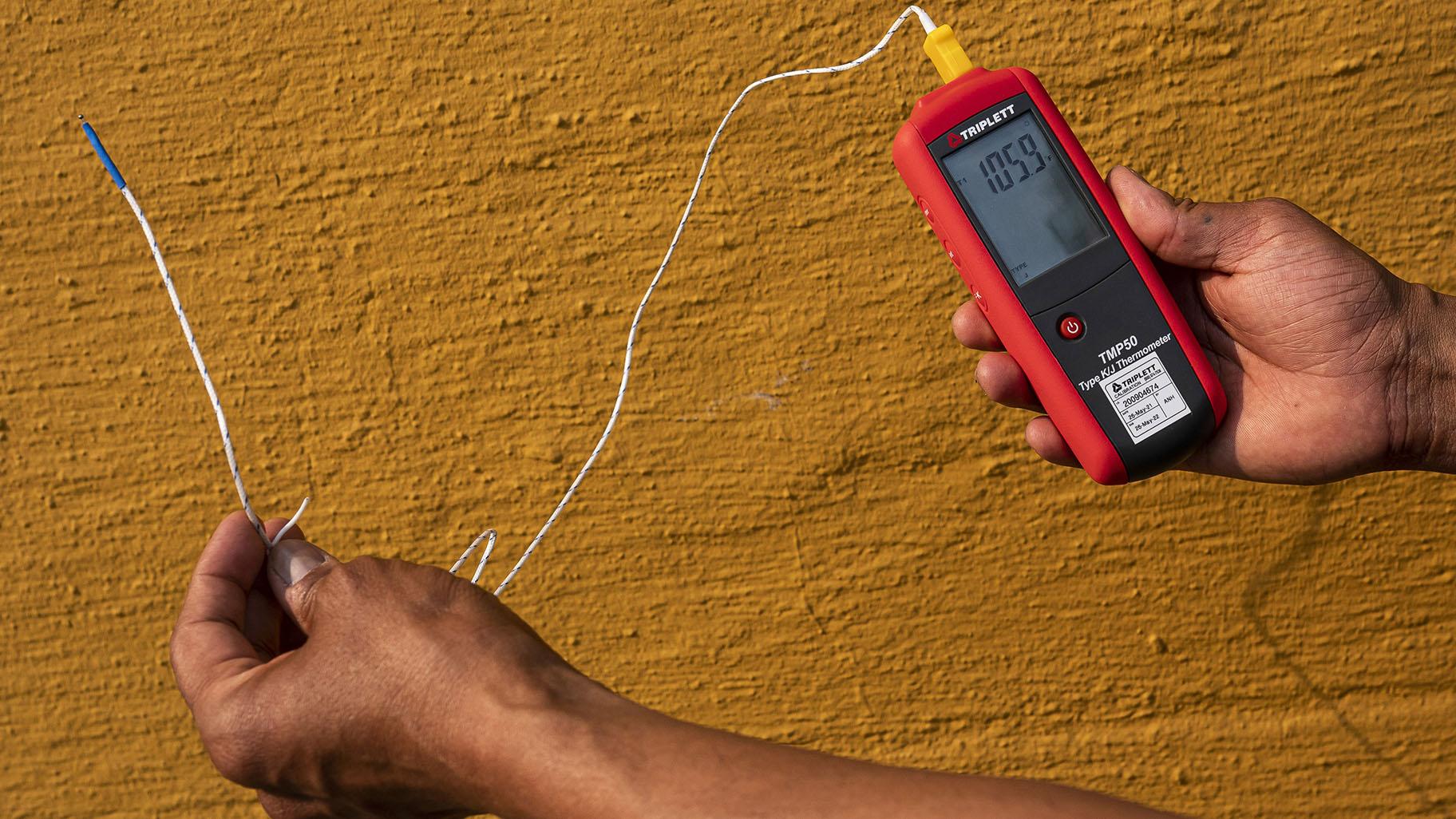 Vivek Shandas, a professor of climate adaptation at Portland State University, takes a temperature reading of almost 106 degrees in downtown Portland, Ore., on Aug. 12, 2021. (Nathan Howard / AP Photo, File)